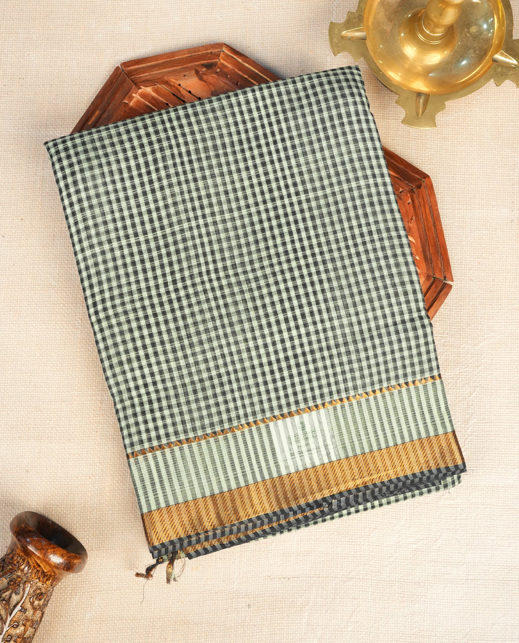Black and pale green Mangalagiri cotton saree with a classic checked body, contrast striped pallu & Gold zari border. Comes with a matching blouse piece.
