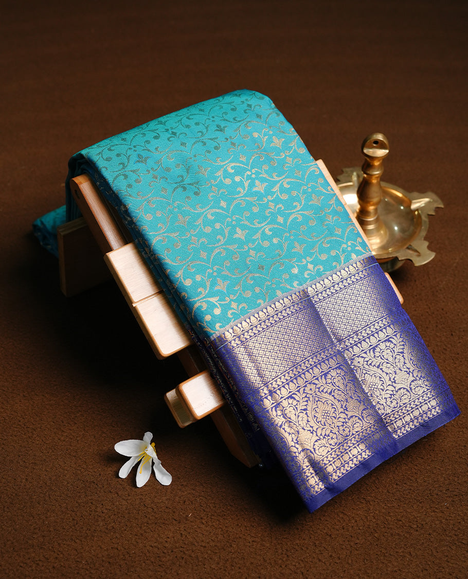 Aqua colour semi wedding saree featuring gold zari pattern on body, complemented by contrast Blue with traditional border, paired with matching blouse piece.