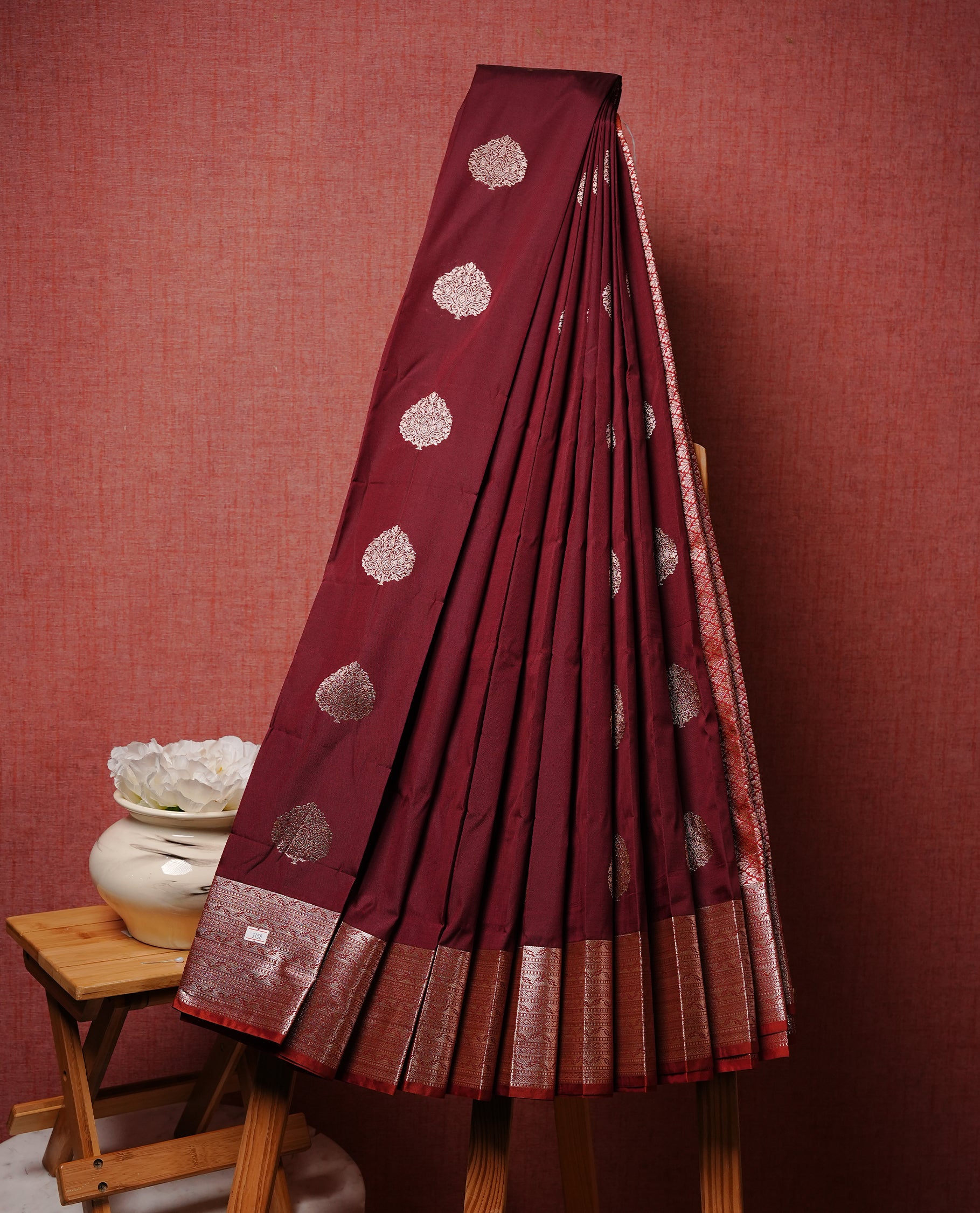 Maroon colour Semi silk saree Featuring gold zari motifs on body, complemented by Self colour with gold zari border, paired with matching blouse piece.
