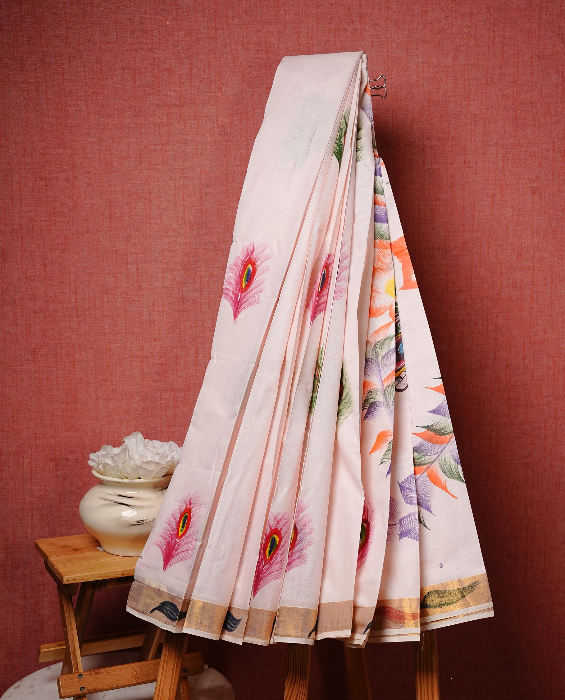 Light pink colour Semi silk saree Featuring Peacock Feather print on body, complemented by Self colour with gold zari border, paired with matching blouse piece.
