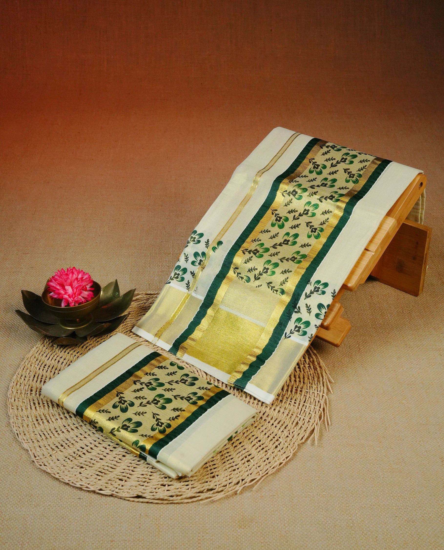Cream Colour tissue set mundu featuring a plain body, enhanced with elegant green floral motifs an a rich gold zari kara