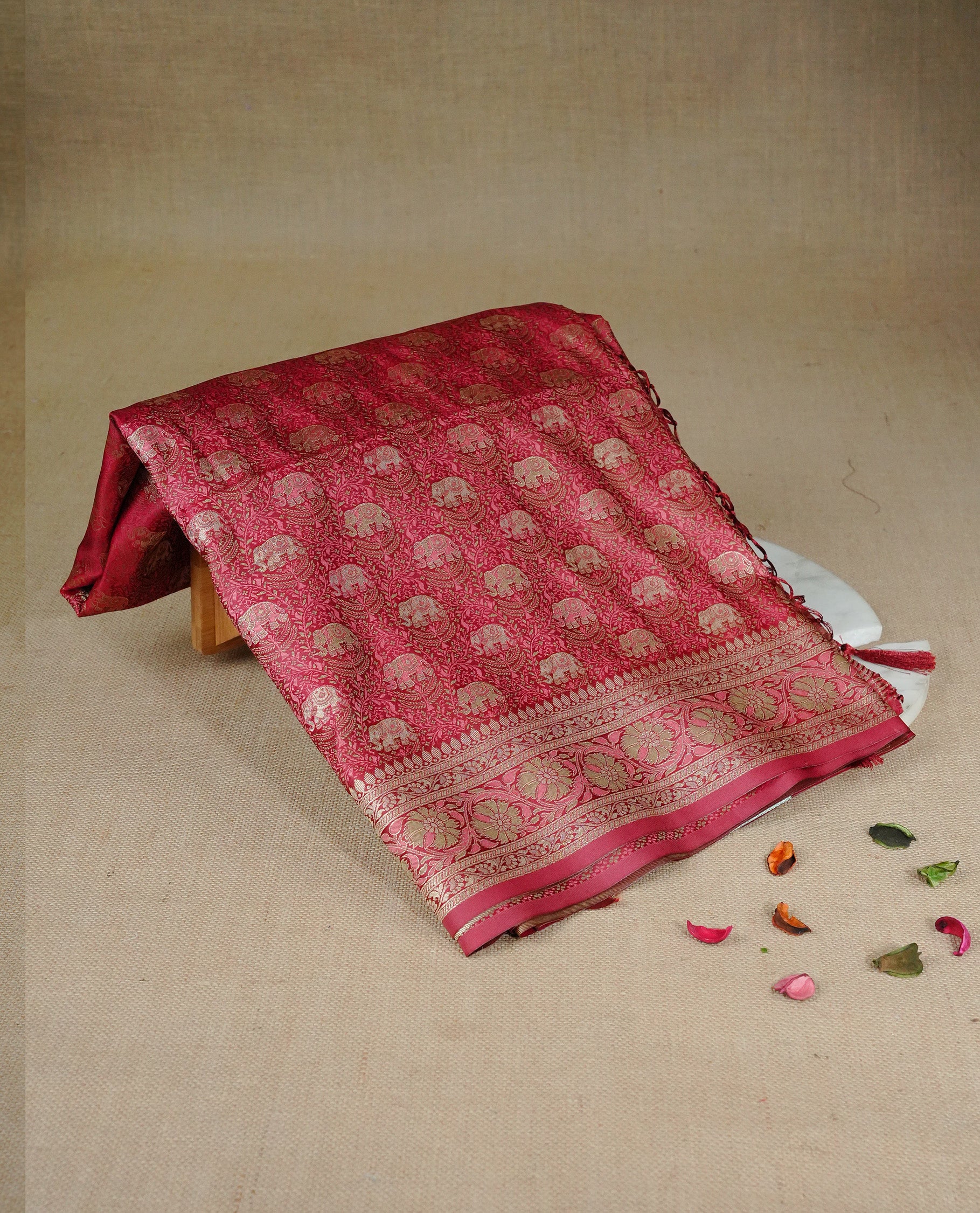 Red colour Mulberry silk saree featuring gold zari elephant & floral kodi pattern across body, complemented by self colour border with gold & orange zari work, comes with matching blouse piece.