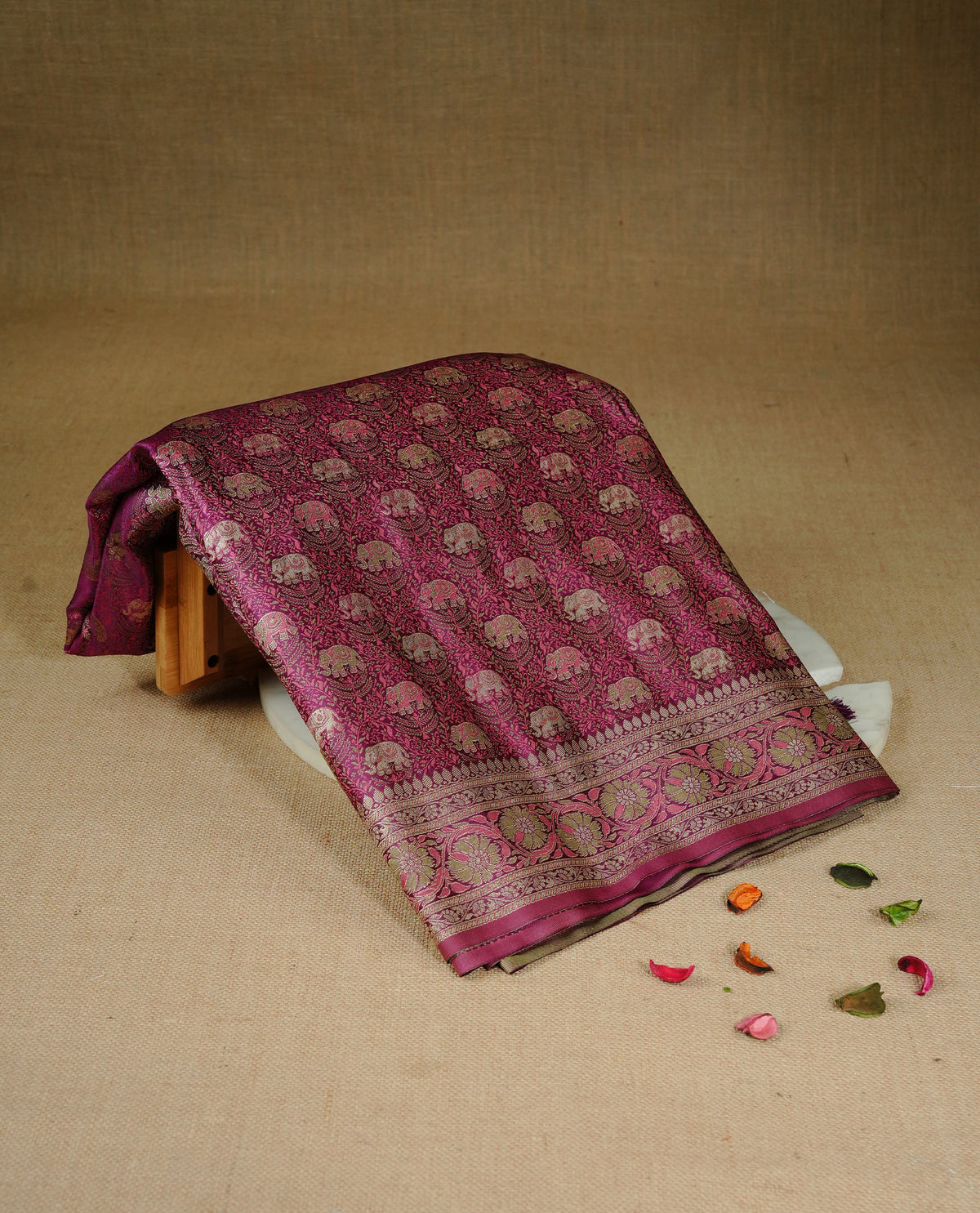 Maroon colour Mulberry silk saree featuring gold zari elephant & floral kodi pattern across body, complemented by self colour border with gold zari work, comes with matching blouse piece.