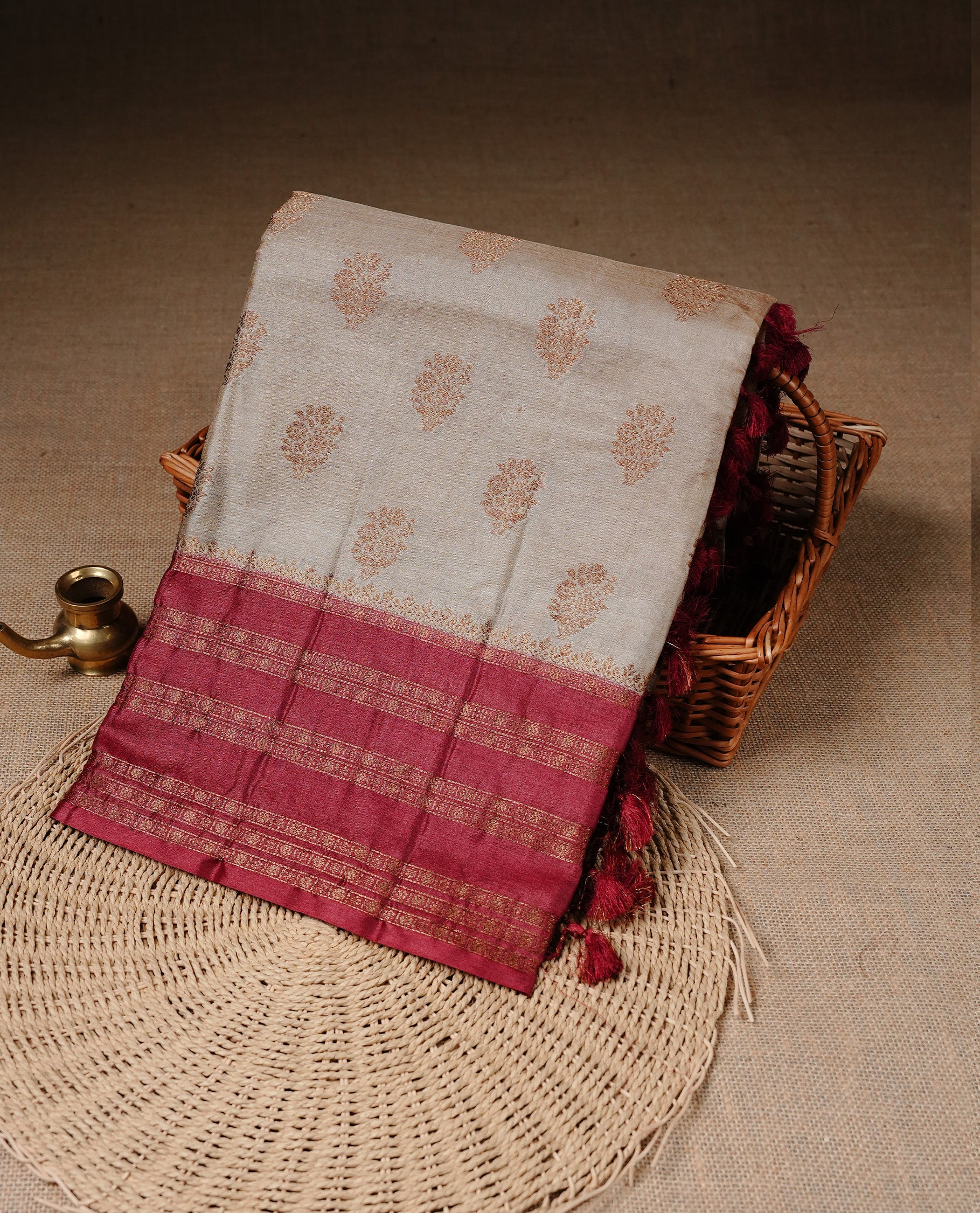 Golden Cream Colour Banaras tussar silk saree featuring Antique zari Motifs on body, Complemented by Maroon colour variant with zari border, paired with matching blouse Piece.