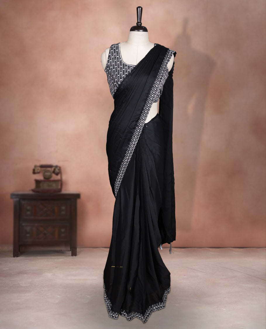 Elegant Black colour ready to wear saree adorned with rich silver stone and bead embroidery along the border and pallu, paired with a heavily embellished matching blouse for a grand festive look.