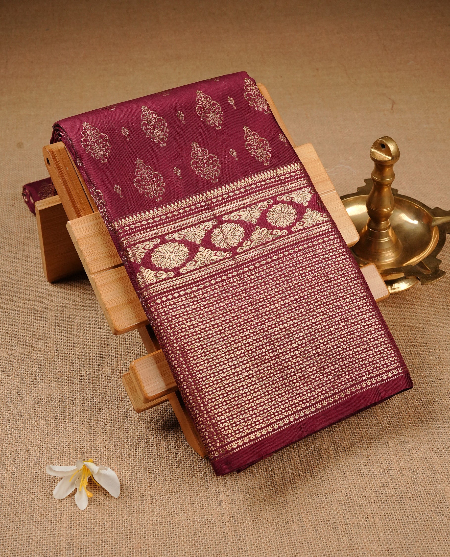 Wine Colour Pure Kancheepuram Silk Saree Featuring Gold Zari Motifs on the Body, Highlighting a Traditional Gold Zari Border, Paired with a Matching Blouse Piece.