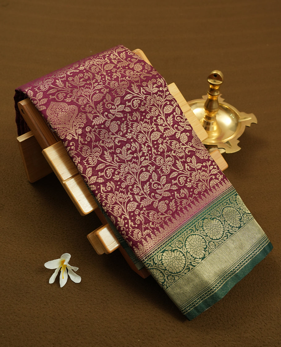 Deep Brown colour semi silk brocade saree featuring intricate Gold Floral kodi patterns across the body, complemented by a contrast rich dark green colour woven border and pallu, paired with a matching blouse.
