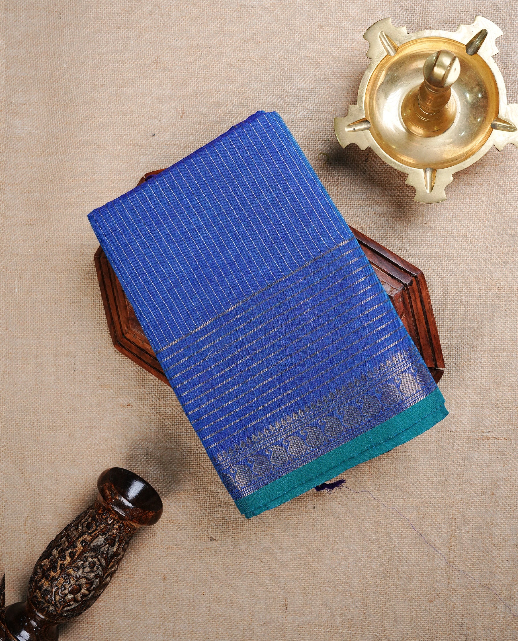 Blue colour chettinad cotton saree featuring Gold zari Stripes on body. complemented by Gold zari stripe & Mango patterned border with Teal piping, paired with matching blouse piece