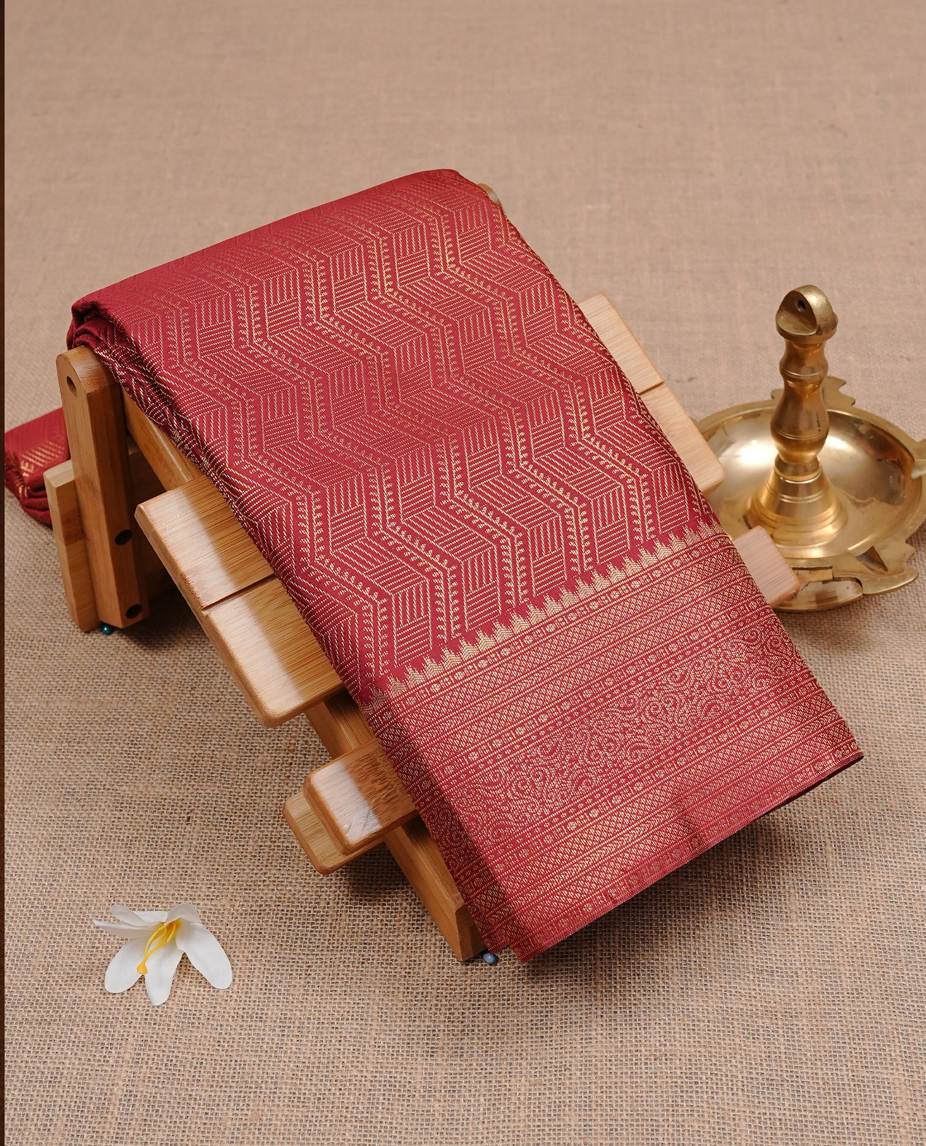 Maroon colour semi wedding silk saree featuring gold zari zigzag pattern on body, enhanced with self colour with traditional border, paired with matching blouse piece.