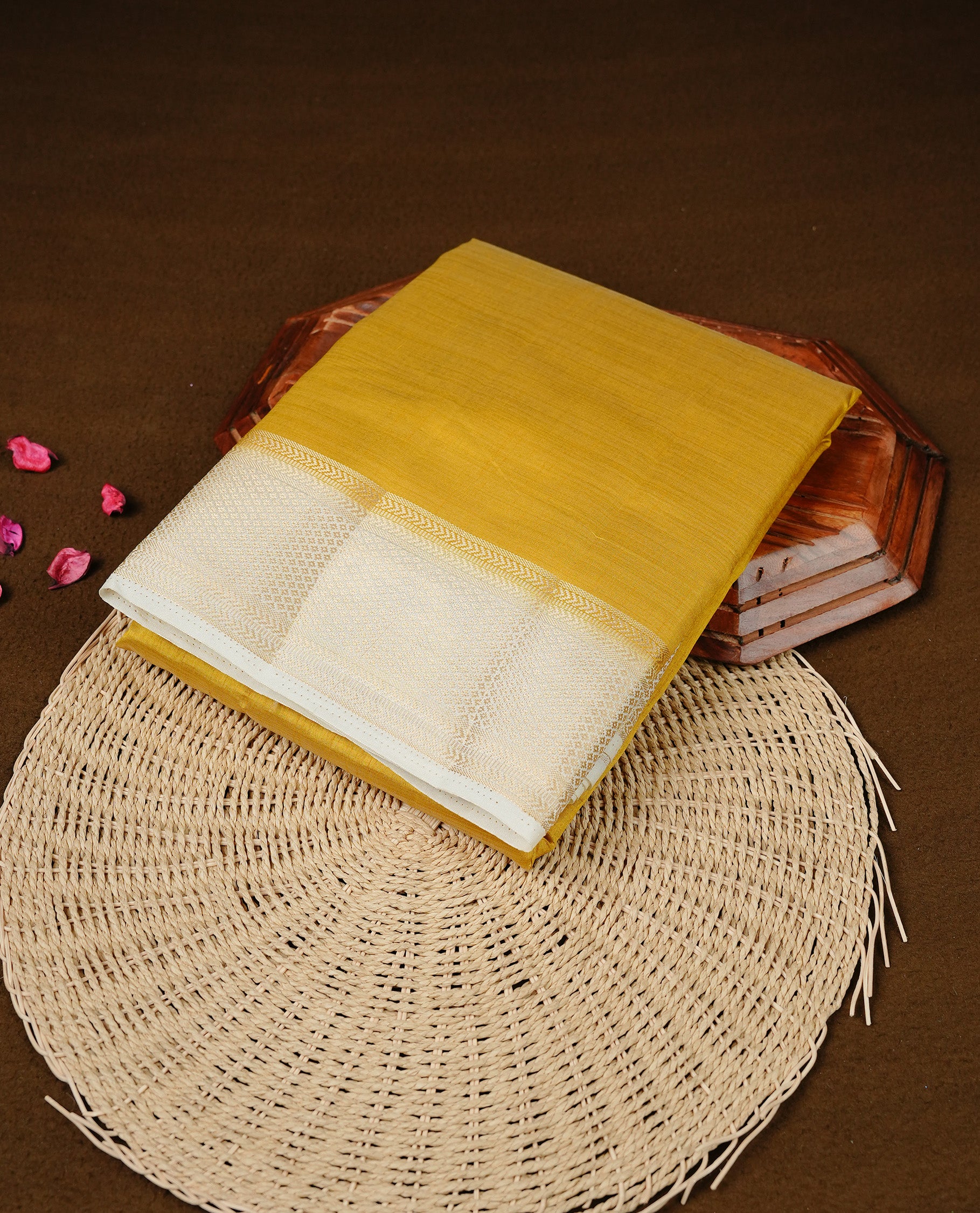 Mustard colour Semi Tussar silk saree featuring an elegant plain body, accentuated by a contrast cream border adorned with intricate gold zari work, paired with a matching blouse piece.