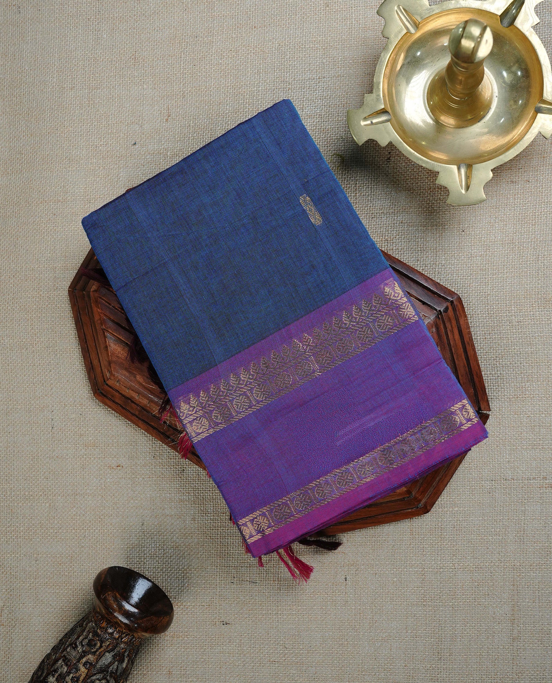 Dark Blue colour chettinad cotton saree featuring Gold Zari Motifs on body, complemented by Contrast Purple Colour With Gold Zari border, paired with matching blouse piece.