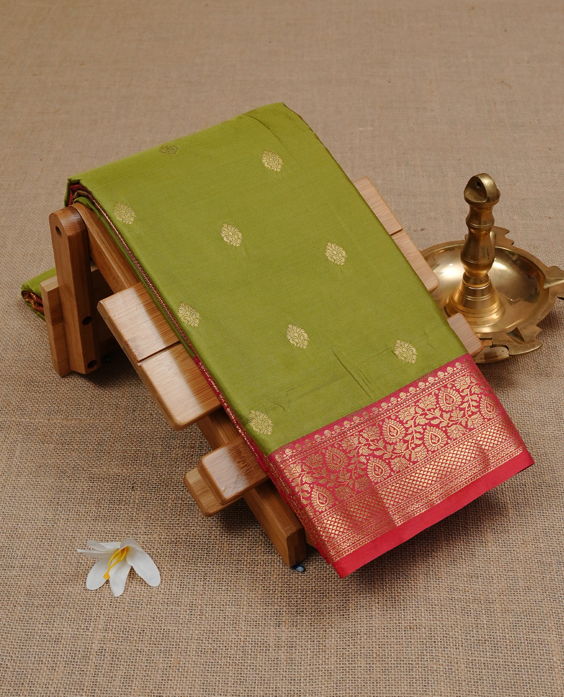 Olive colour semi Wedding silk saree featuring Gold zari motifs on body, enhanced with Contrast red colour with traditional border, paired with matching blouse piece.