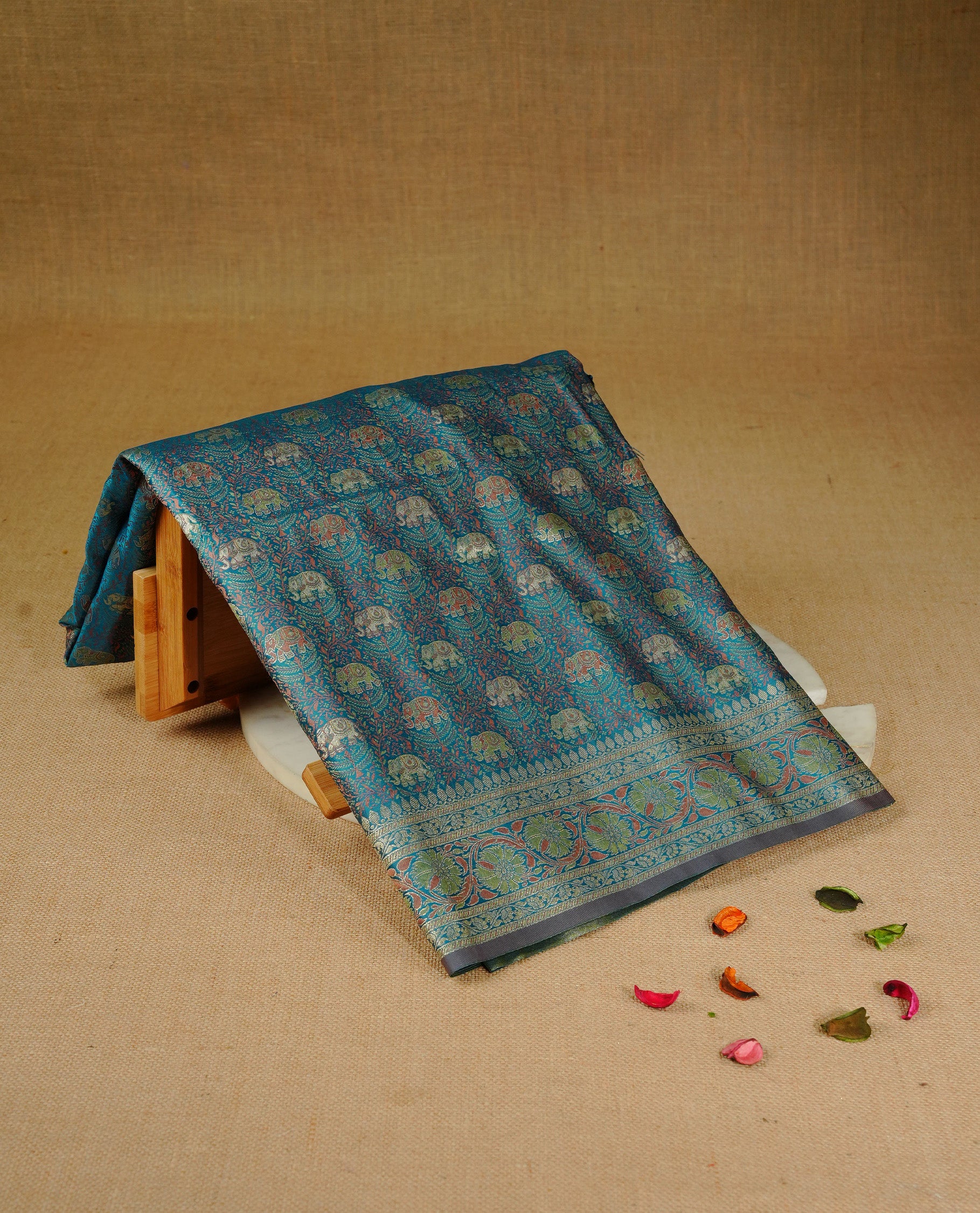 Teal colour Mulberry silk saree featuring gold zari elephant & floral kodi pattern across body, complemented by self colour border with gold zari work, comes with matching blouse piece.