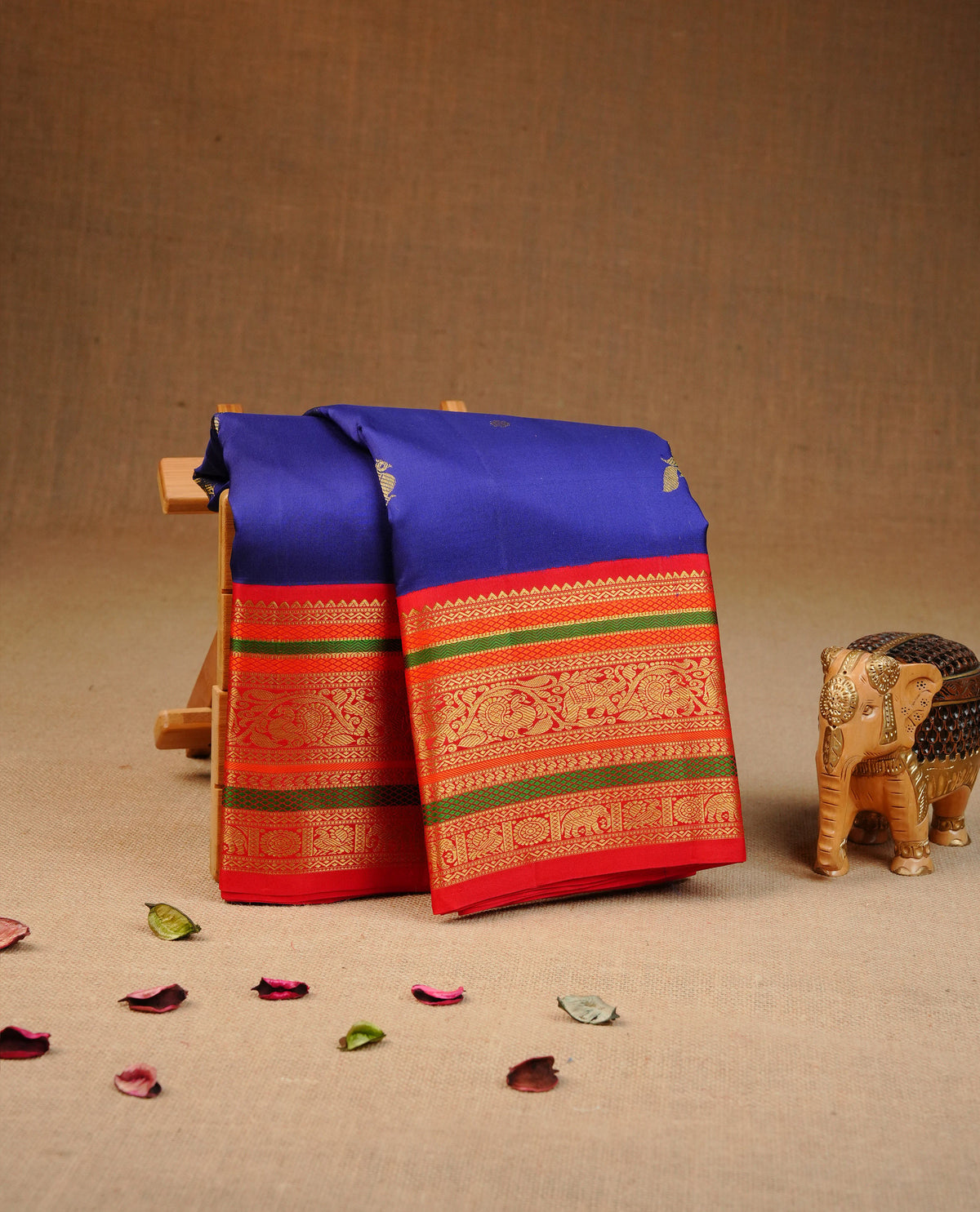 Navy blue colour traditional kancheepuram silk saree featuring Gold zari buttas, contrast multi colour with traditional border, comes with matching blouse piece.