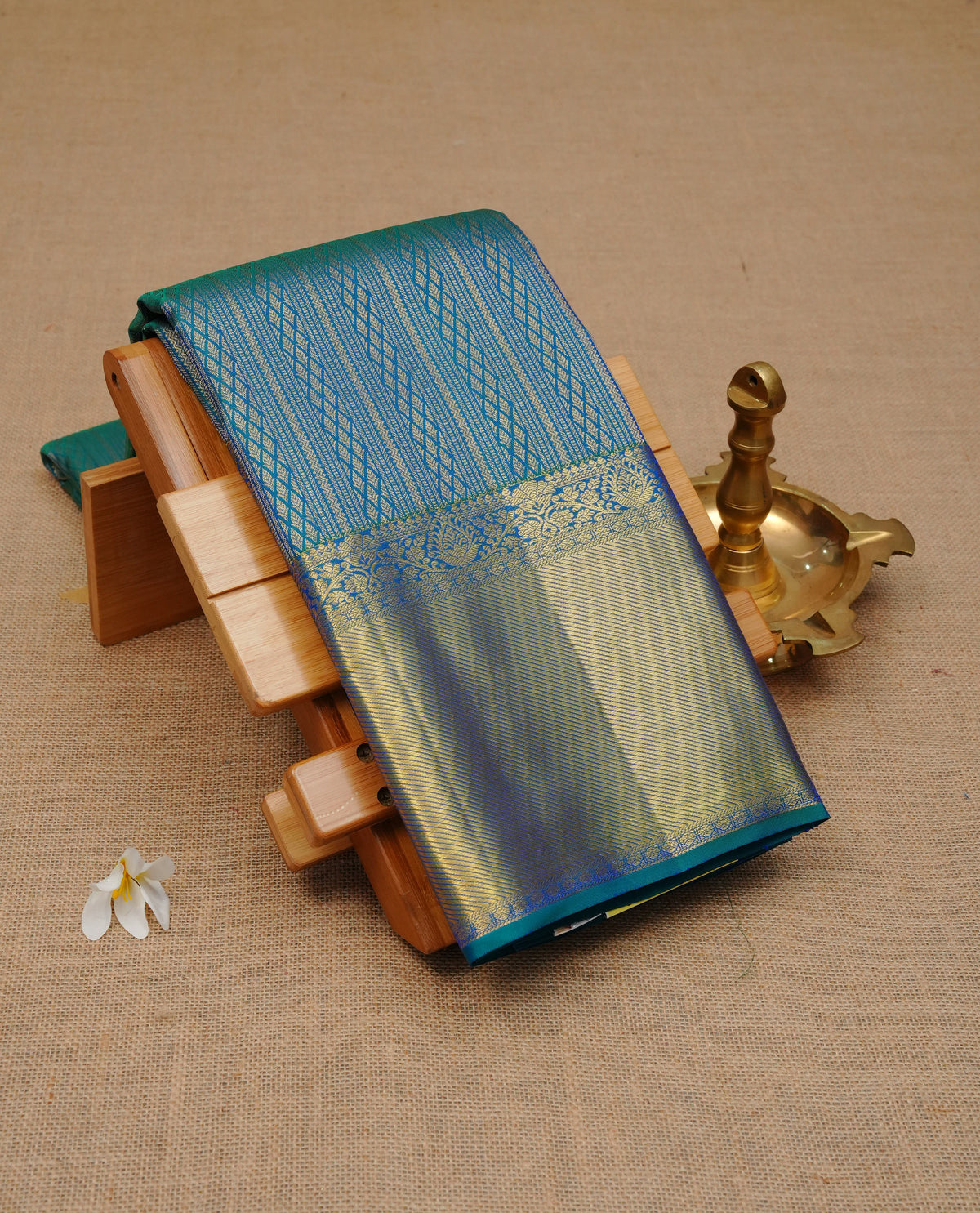 Peacock colour pure wedding silk saree featuring gold zari designed strips pattern on body, complemented by self colour with traditional border, comes with matching blouse piece.