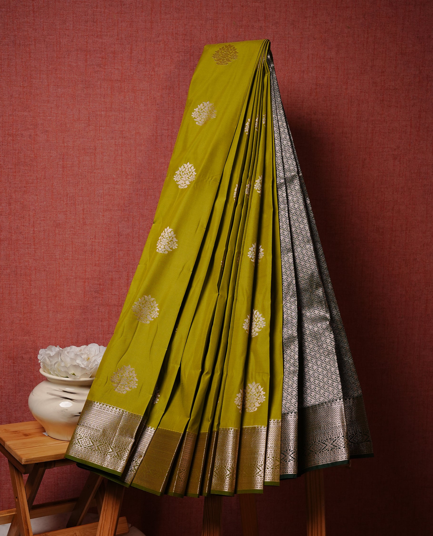Olive colour Semi silk saree Featuring gold zari motifs on body, complemented by Contrast Green colour with gold zari border, paired with matching blouse piece.