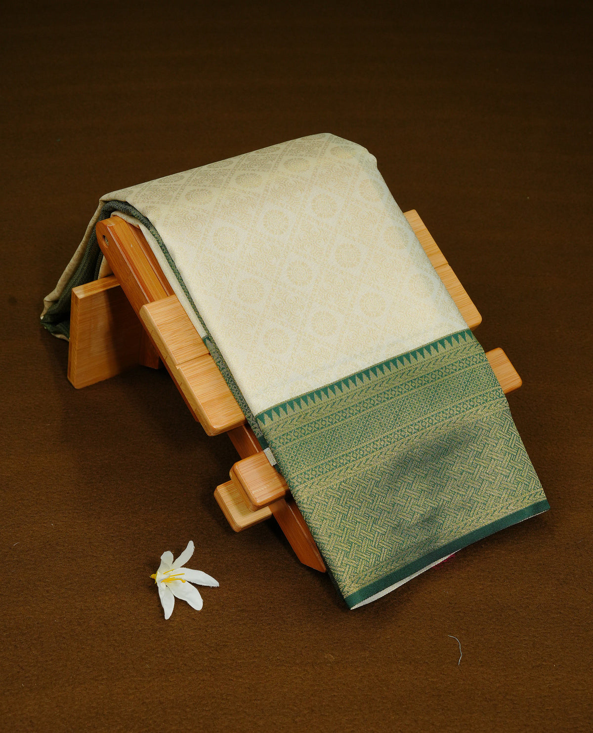 Cream Colour Semi Soft Silk Saree Featuring Gold zari Box With motifs Pattern On Body, Highlighted by contrast Dark Green border with Gold zari, paired with matching blouse piece.