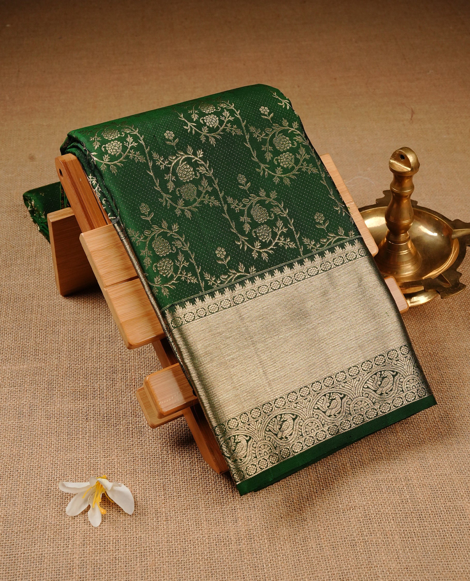 Dark Green Colour Pure Kancheepuram Silk Saree Featuring Silver Zari Floral Kodi Pattern on the Body, Highlighting a Traditional Silver Zari Border, Paired with a Matching Blouse Piece.