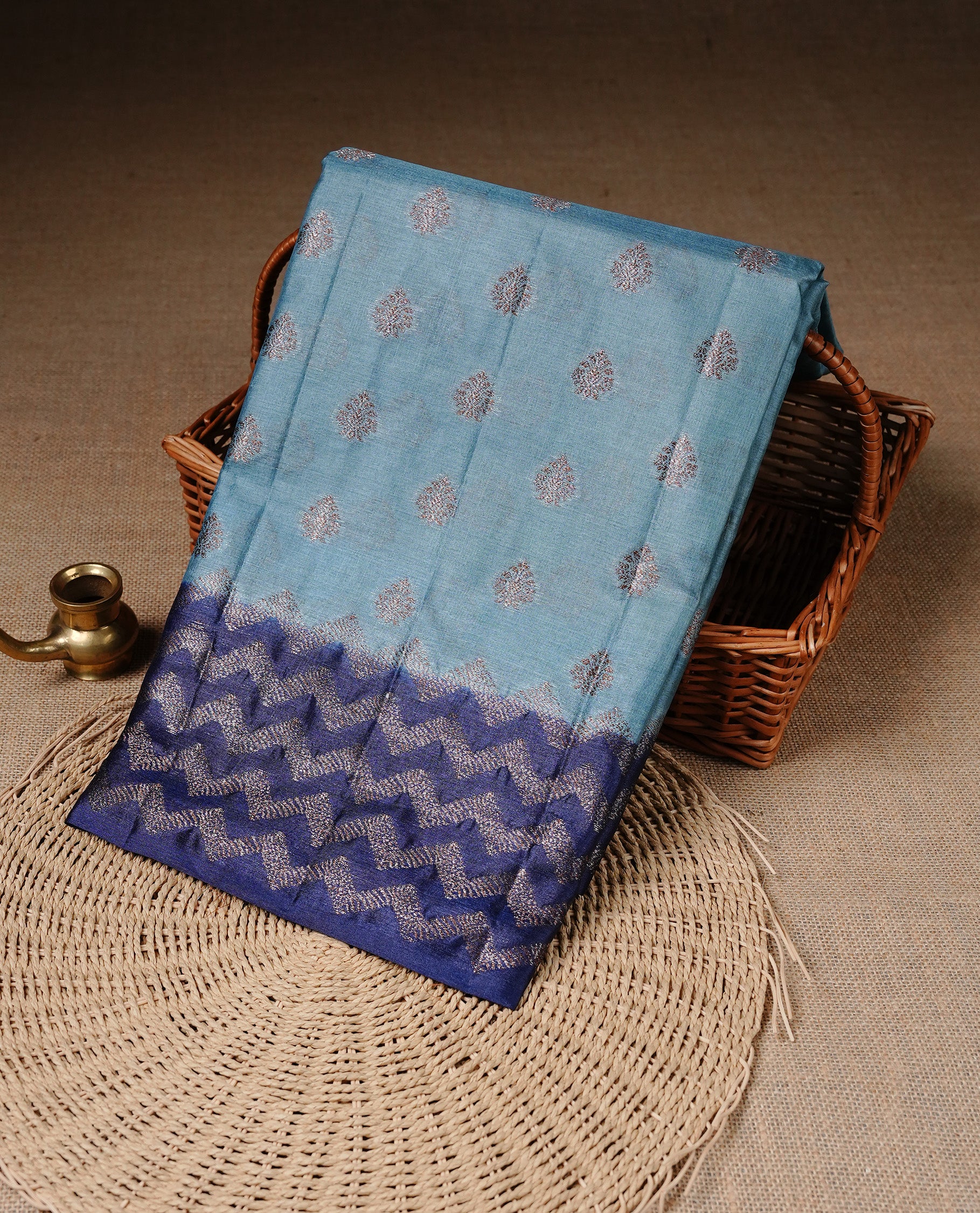 Aqua Blue Colour Tussar silk saree featuring Antique Zari motifs on body, Finished with contrast Blue colour Zigzag zari pattern border, paired with matching blouse piece.