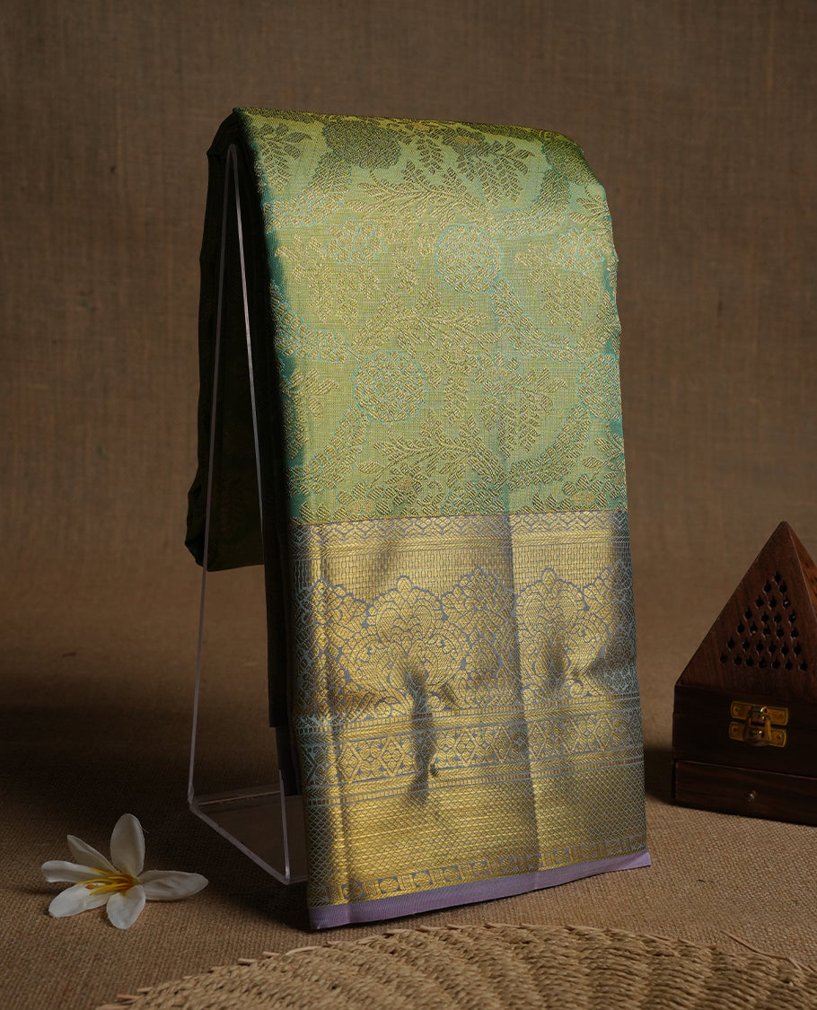 Light pastel green & gold double shade colour kancheepuram tissue silk saree highlighting gold zari pattern body, with contrast lavender colour colour with traditional border and paired with matching blouse.