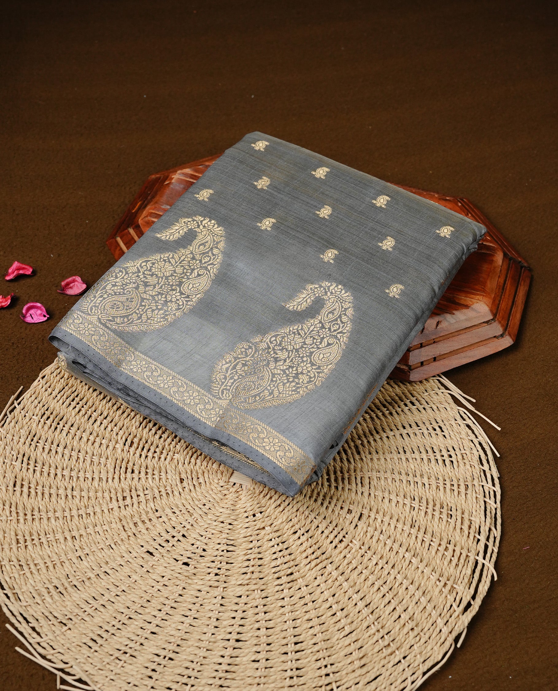 Grey colour semi tussar silk saree featuring small gold zari mango motifs across the body, enhanced with a self colour border showcasing elegant gold zari mango patterns. Paired with a matching blouse piece.