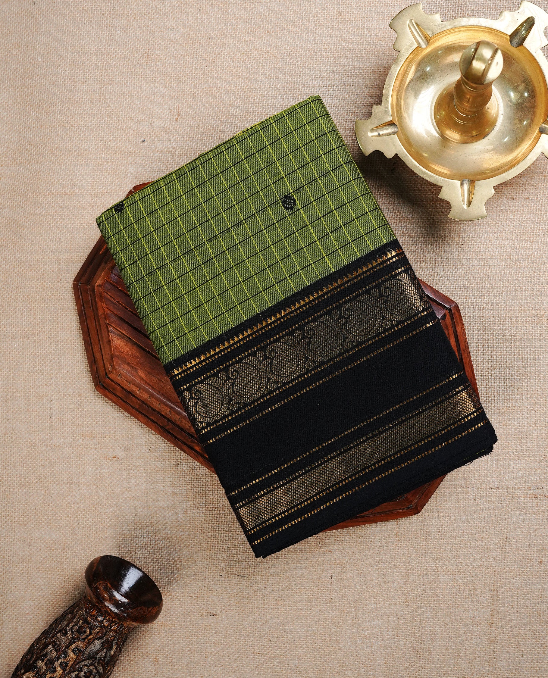 Green colour Chettinad cotton saree featuring Black check pattern on body, complemented by Contrast Black colour With gold zari mango patterned border, paired with matching blouse piece.