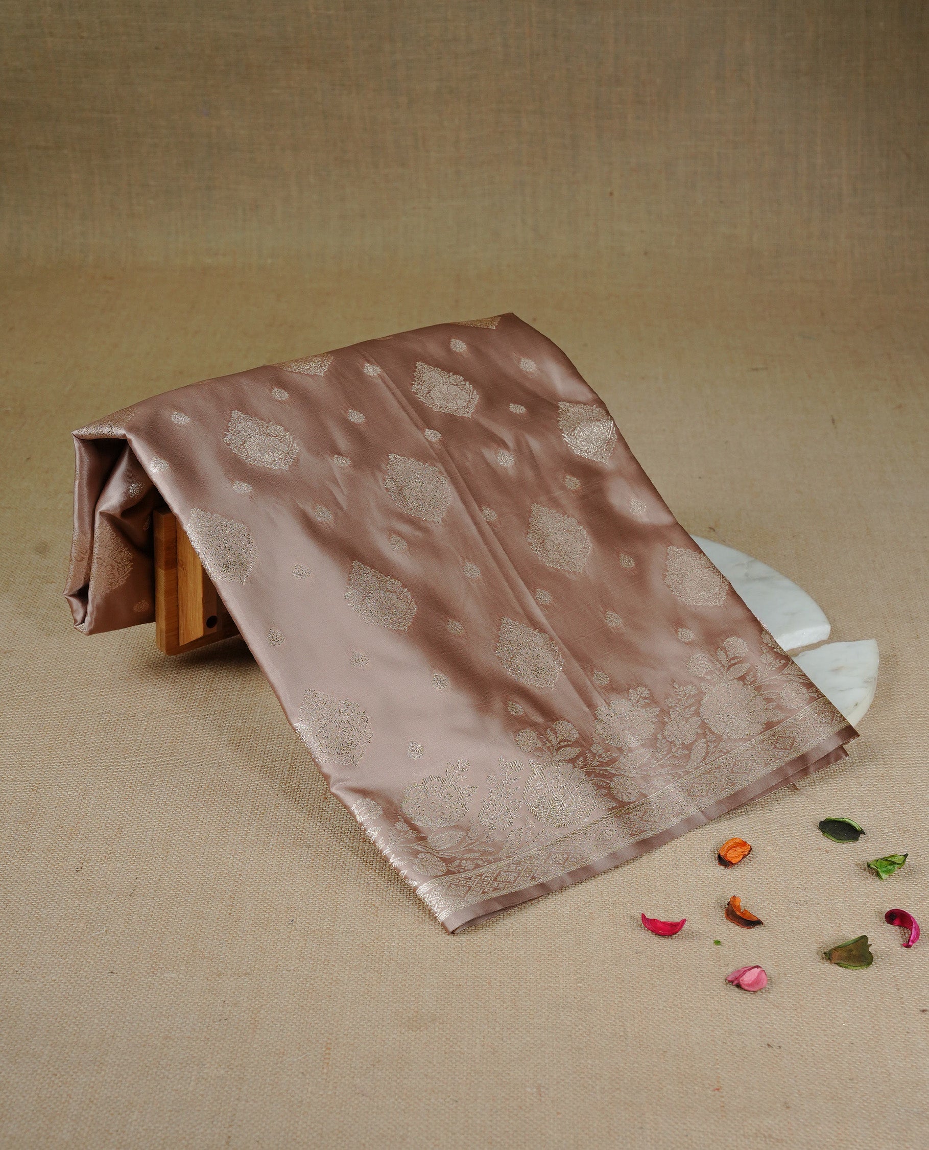 Muted Beige gold colour Mulberry silk saree featuring light gold small buttas & big motifs onbody, complemented by self colour with Light gold zari floral Border, comes with matching blouse piece.