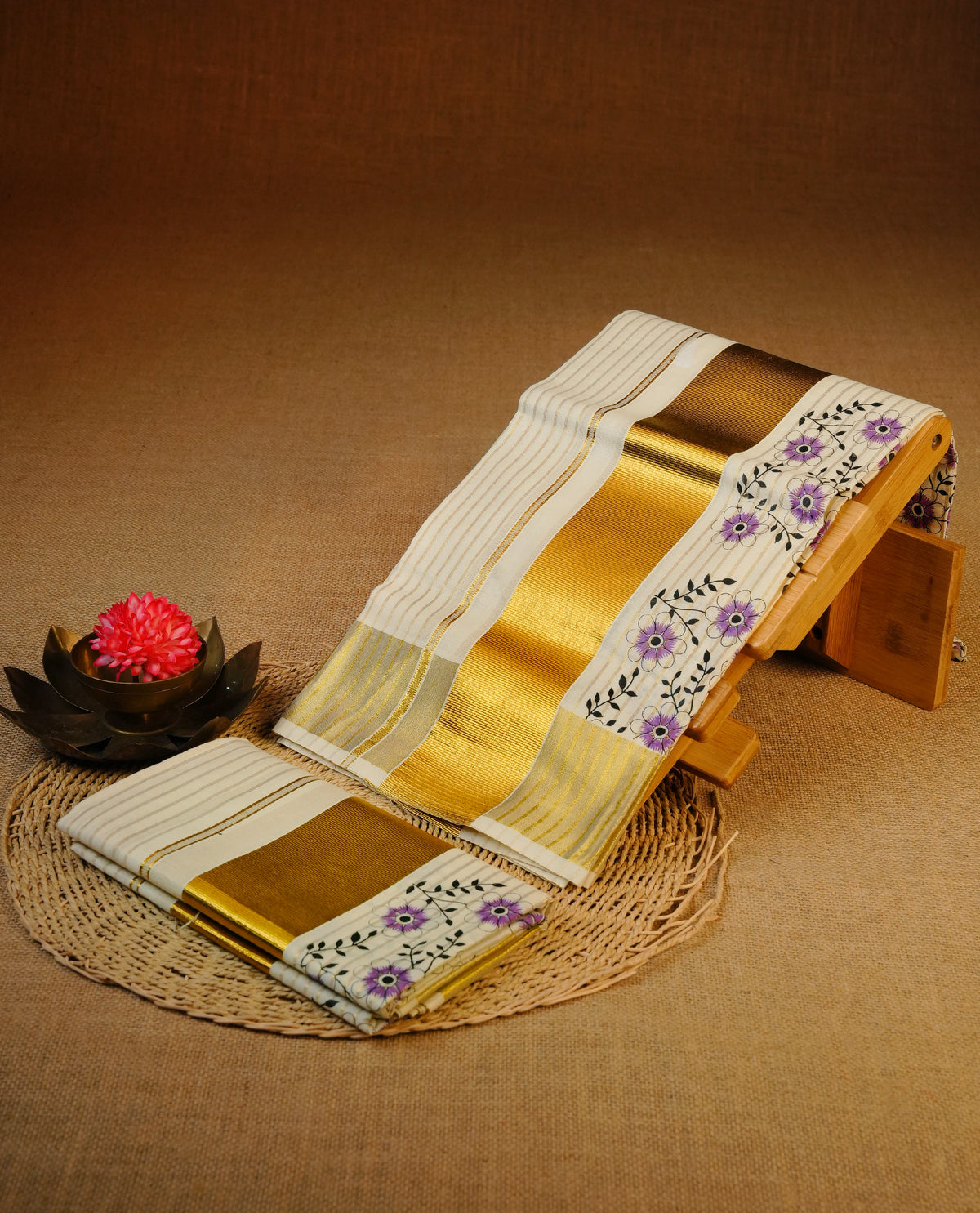 Cream colour cotton set mundu featuring Gold strips on body, gold kasav with Purple Floral print kara.