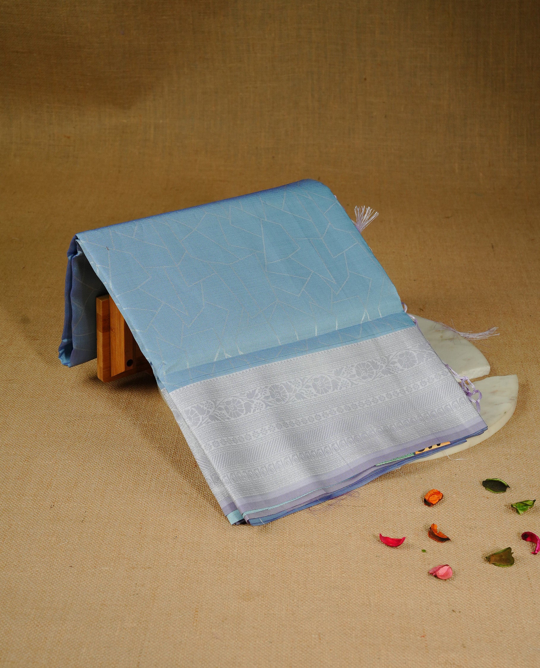Sky blue colour semi silk saree featuring Silver zari Geometric pattern on body, complemented by contrast Lavender colour with silver zari border, comes with matching blouse piece.