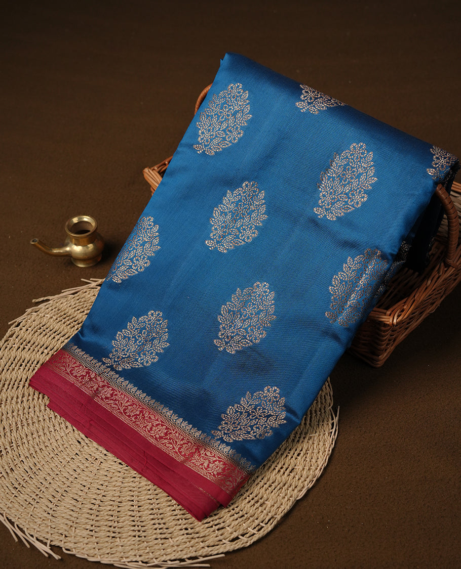 Blue colour Pure tussar Banarasi saree featuring Gold zari motifs on body, by contrast deep red colour gold zari border border, and a matching blouse piece.