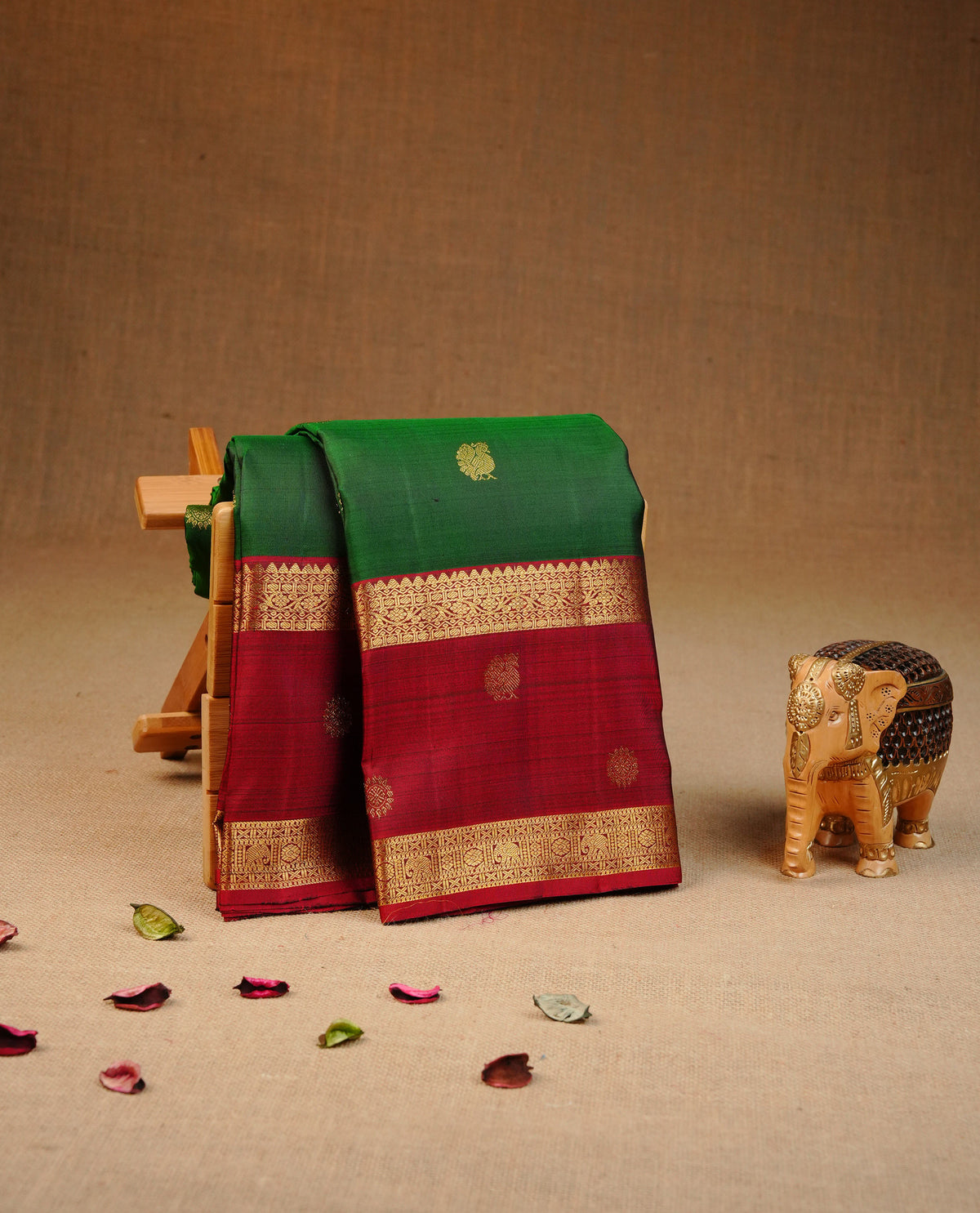 Bottle green colour traditional kancheepuram silk saree featuring gold zari buttas on body, contrast Maroon colour Border, comes with matching blouse piece.