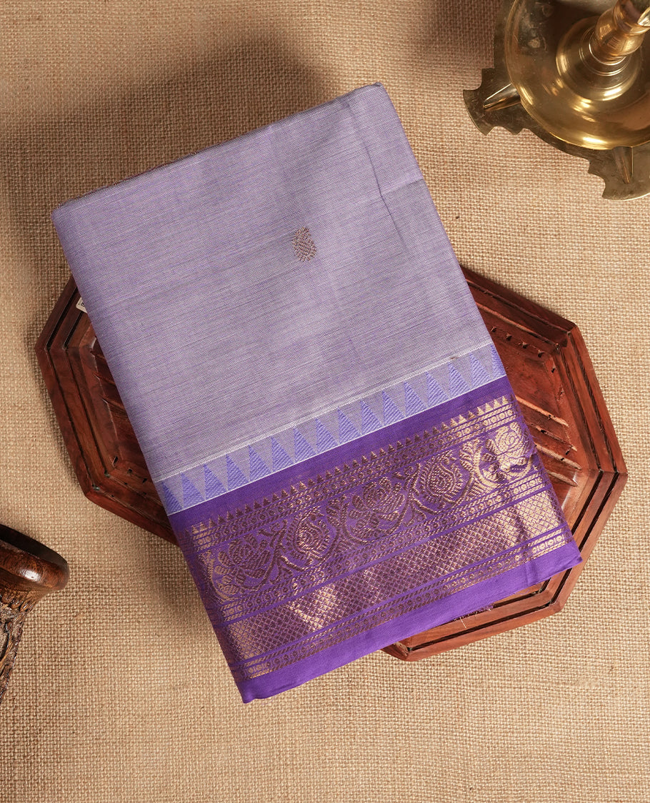 Lavender colour Chettinad cotton saree featuring subtle small motifs on the body, The saree is highlighted with a rich purple zari woven border adorned with floral and geometric patterns & Comes with a matching blouse piece.