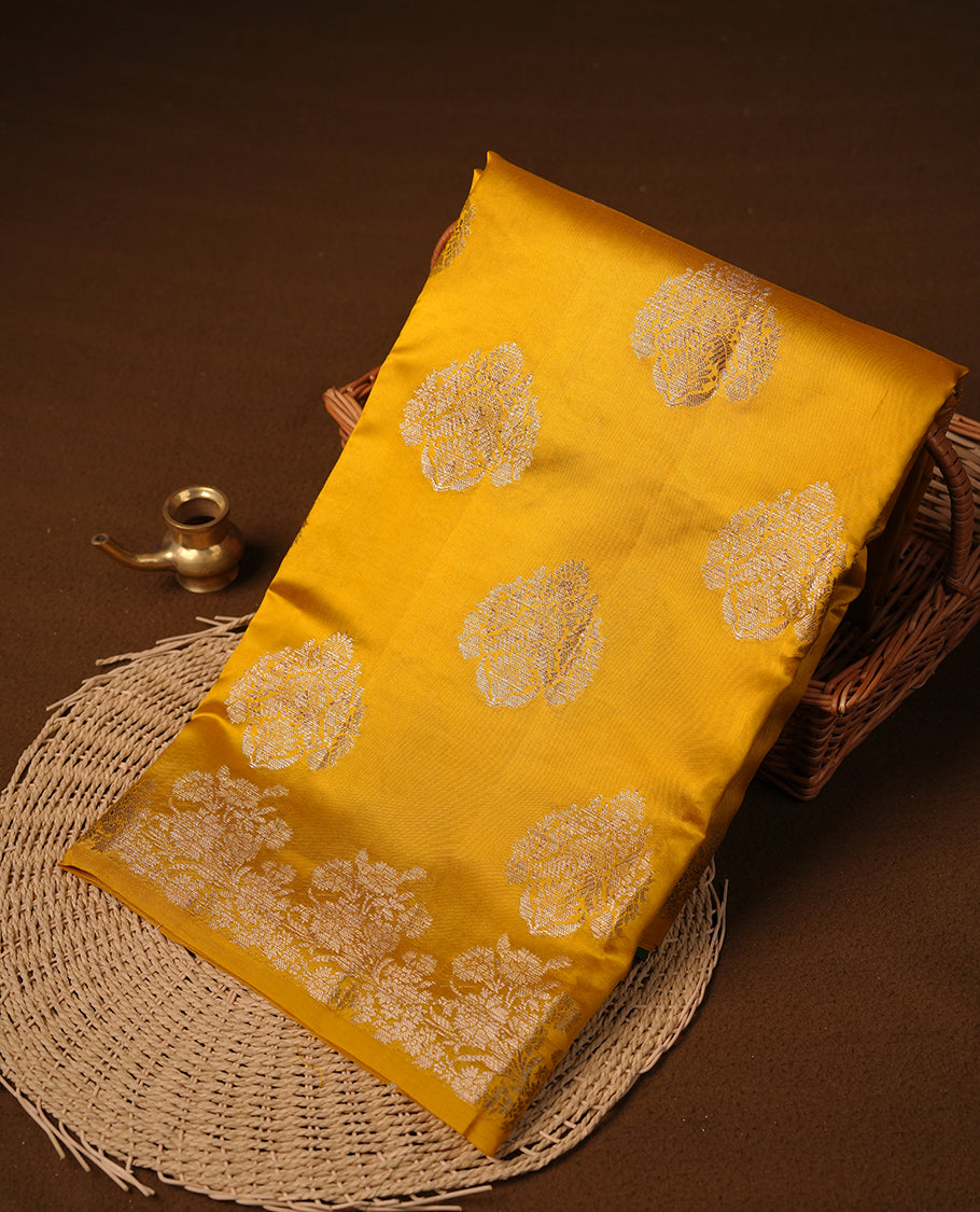 Yellow colour pure tussar Banarasi saree featuring Gold zari motifs on body, self colour border, and a contrast green colour blouse piece.