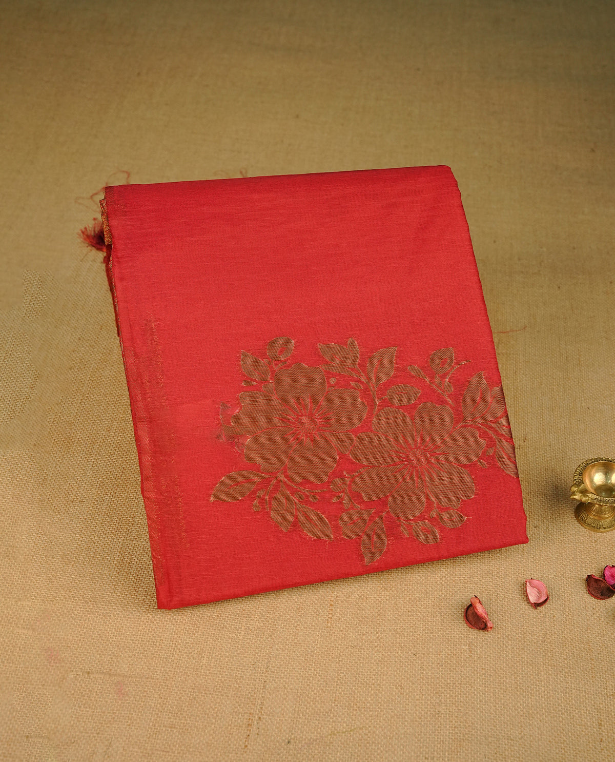 Red colour semi linen saree with elegant gold zari floral motifs across the body, complemented by a contrast colour grand gold zari pallu and a borderless design, paired with a matching blouse piece.