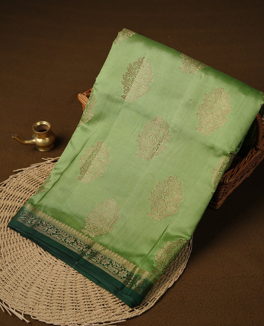 Light green colour Pure tussar Banarasi saree featuring Gold zari motifs on body, a contrast green colour gold zari border, and blouse piece.
