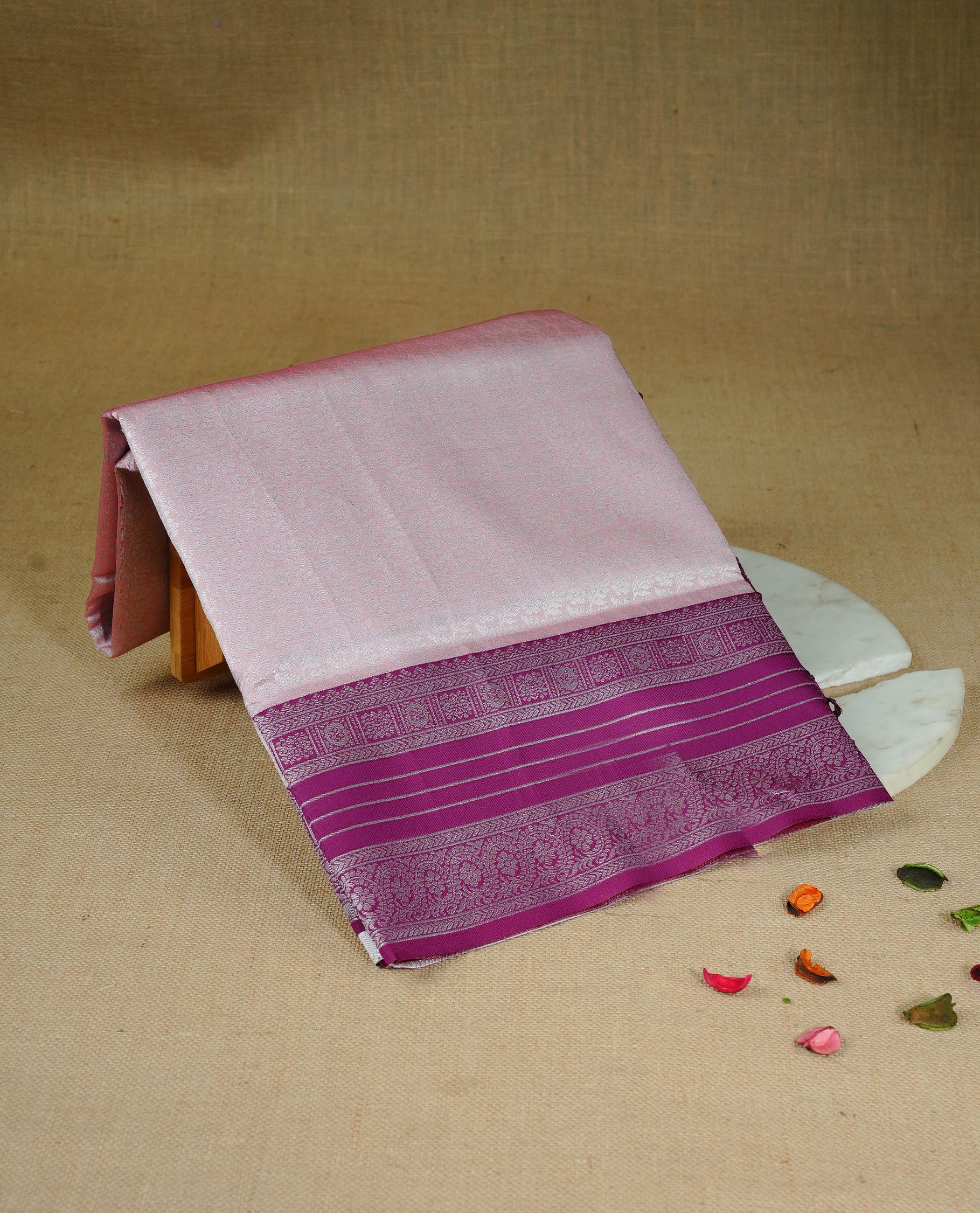 Pink colour semi silk saree featuring Silver zari Floral pattern on body, complemented by contrast Purple colour with silver zari border, comes with matching blouse piece.