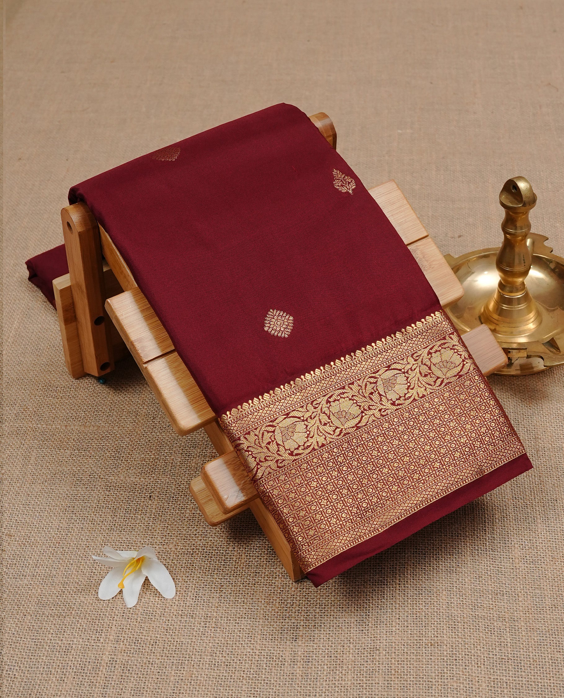 Maroon Semi Wedding Silk Saree featuring Gold Zari Motifs On body, Complemented with traditional zari with Self colour border, paired with matching blouse piece.