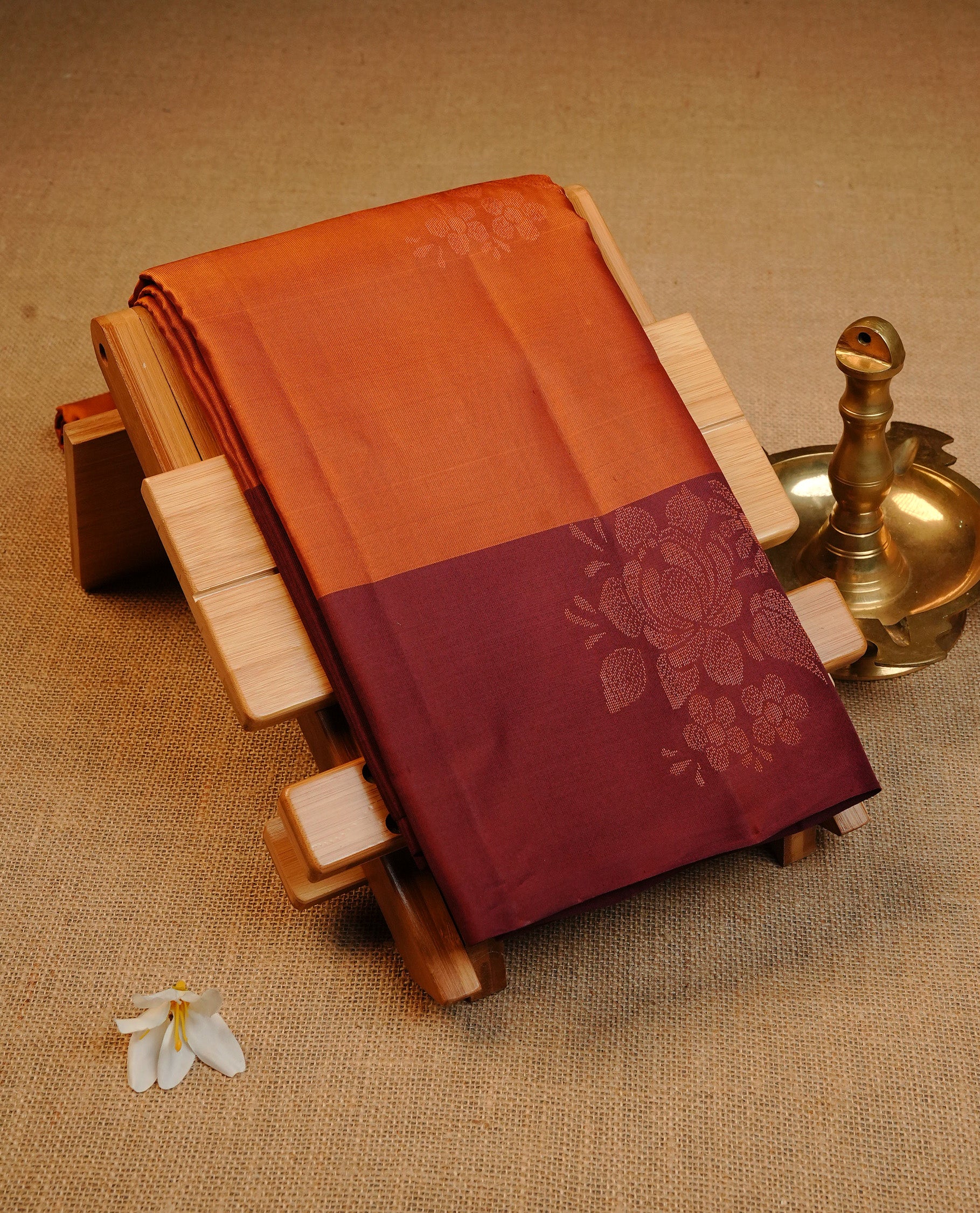 Rust Orange Colour Traditional Kancheepuram Silk Saree Featuring Copper Zari Floral Motifs on the Body, Designed With a Copper Zari Maroon Border and with a Grand Maroon Pallu, Paired with a Matching Blouse.