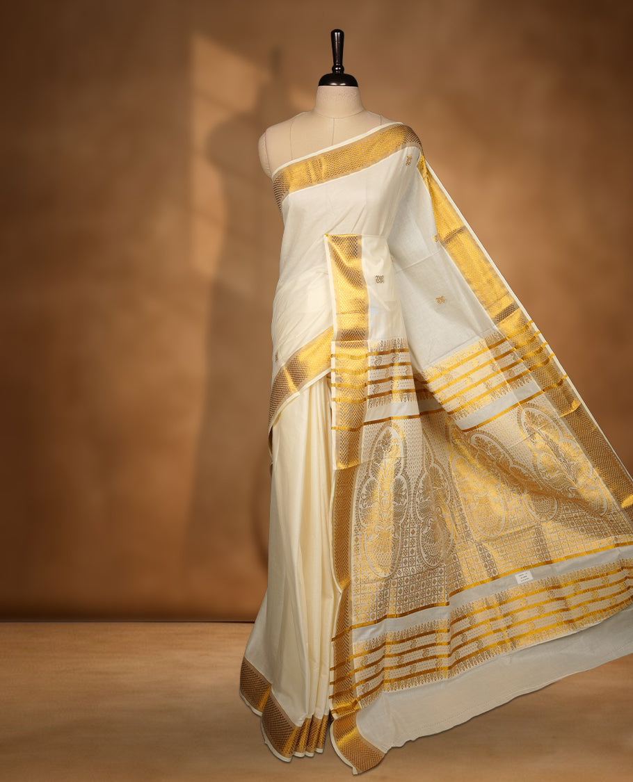 Elegant off white colour cotton Kerala saree with gold zari buttas, broad kasavu border, and richly woven traditional pallu, paired with a matching blouse