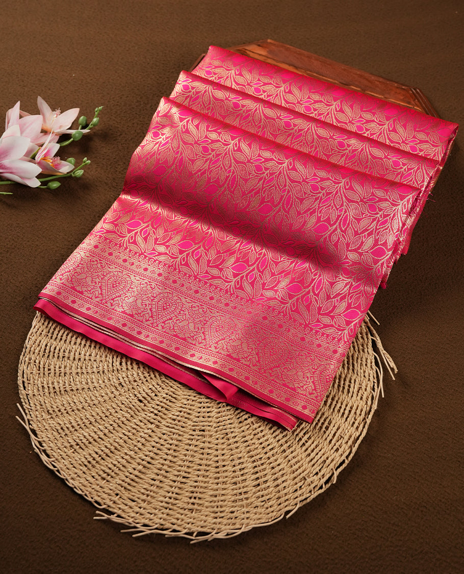 Dark Magenta colour semi soft silk saree featuring an all-over woven leaf pattern in gold colour, finished with a matching border adorned with detailed paisley and floral motifs, and a matching blouse piece.