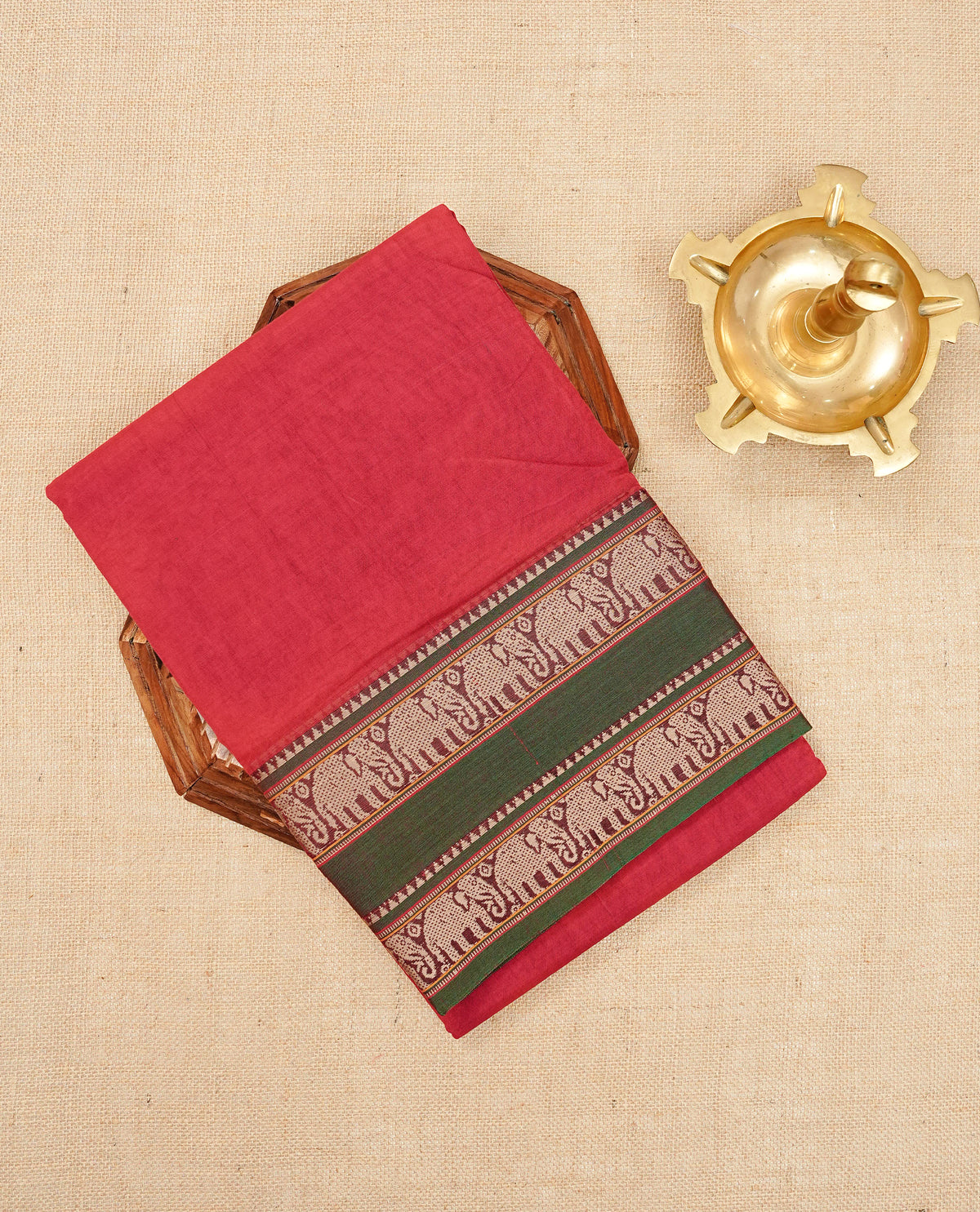 Red colour Narayanapattu cotton saree with a plain body, complemented by a green colour with Beige colour Elephant designed border & contrast pallu, paired with a matching blouse piece.