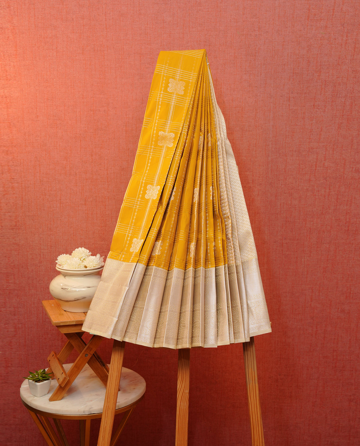 Mustard yellow colour soft silk saree featuring gold zari checks with floral mottifs on body, contrast cream colour gold zari traditional border, grand pallu comes with matching blouse piece.