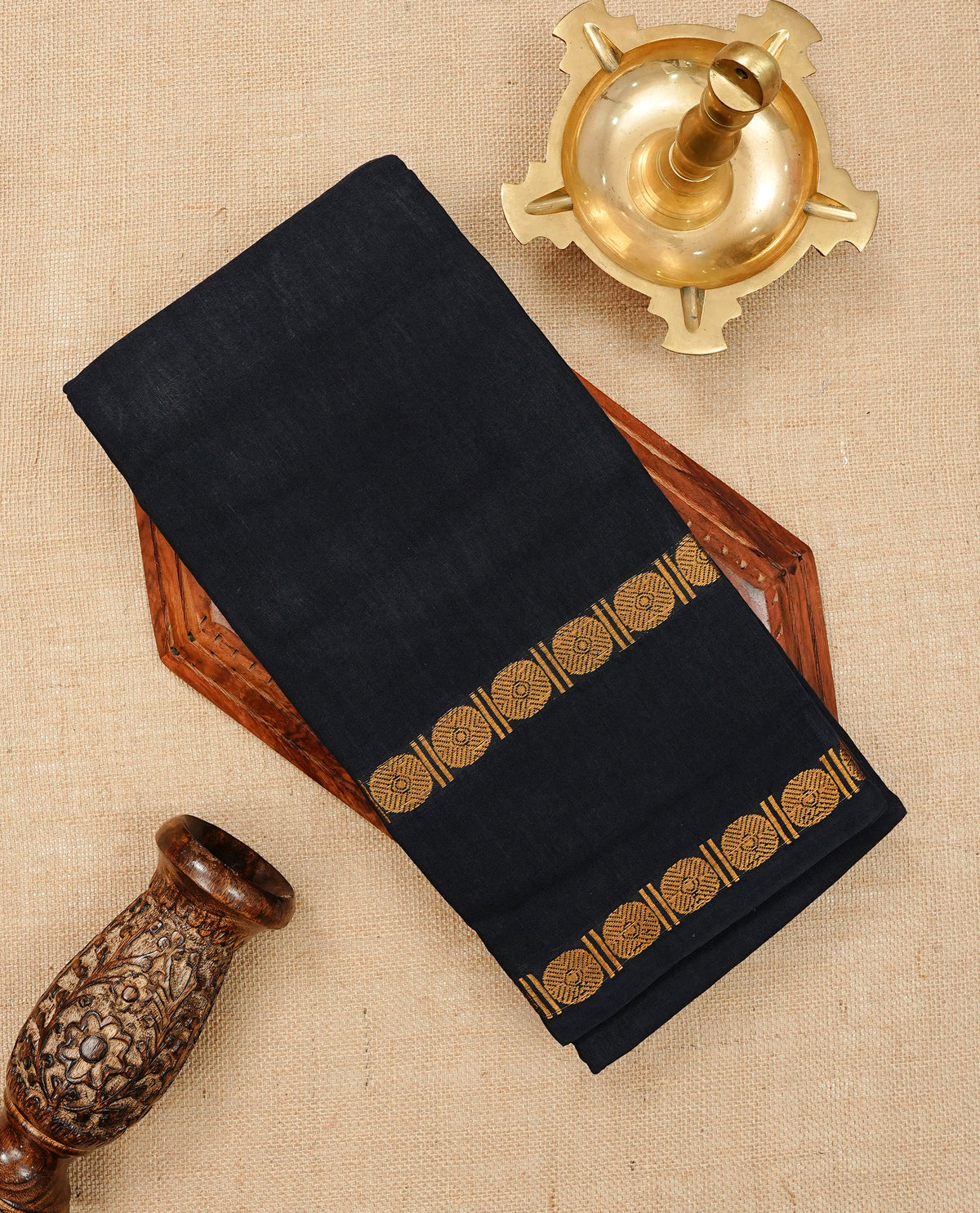 Black Colour Sungudi Cotton Saree with gold zari motifs on the body, a matching gold zari border, and a plain pallu. Paired with a contrast Orange colour blouse piece featuring a gold zari peacock border.