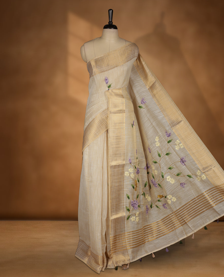 Beige colour Banarasi linen silk saree featuring hand brushed colour with Floral & birds printed pattern on body, gold zari woven geometric design border with self colour pallu and comes with a matching blouse