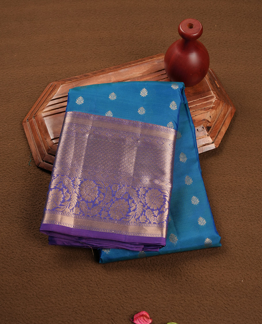 Peacock colour Soft silk saree featuring gold zari floral motifs on the body, complemented by a contrast Indigo traditional zari floral kodi border and pallu, paired with a matching blouse piece.
