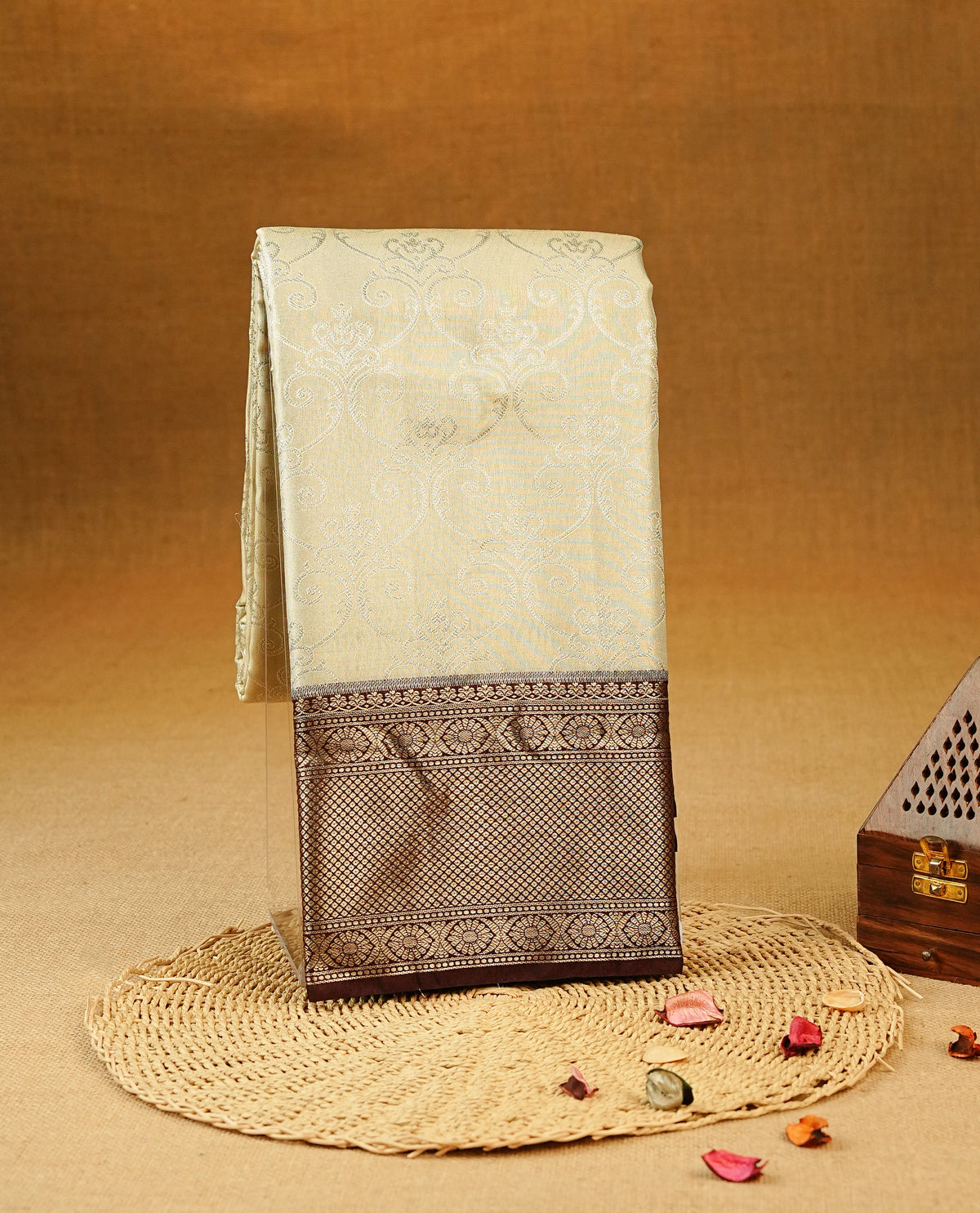 Beige Colour Tissue Silk Saree featuring an elegant Silver zari woven body, a richly woven Gold zari pallu, complemented by a Dark Brown With Gold zari border and paired with a Matching blouse piece.