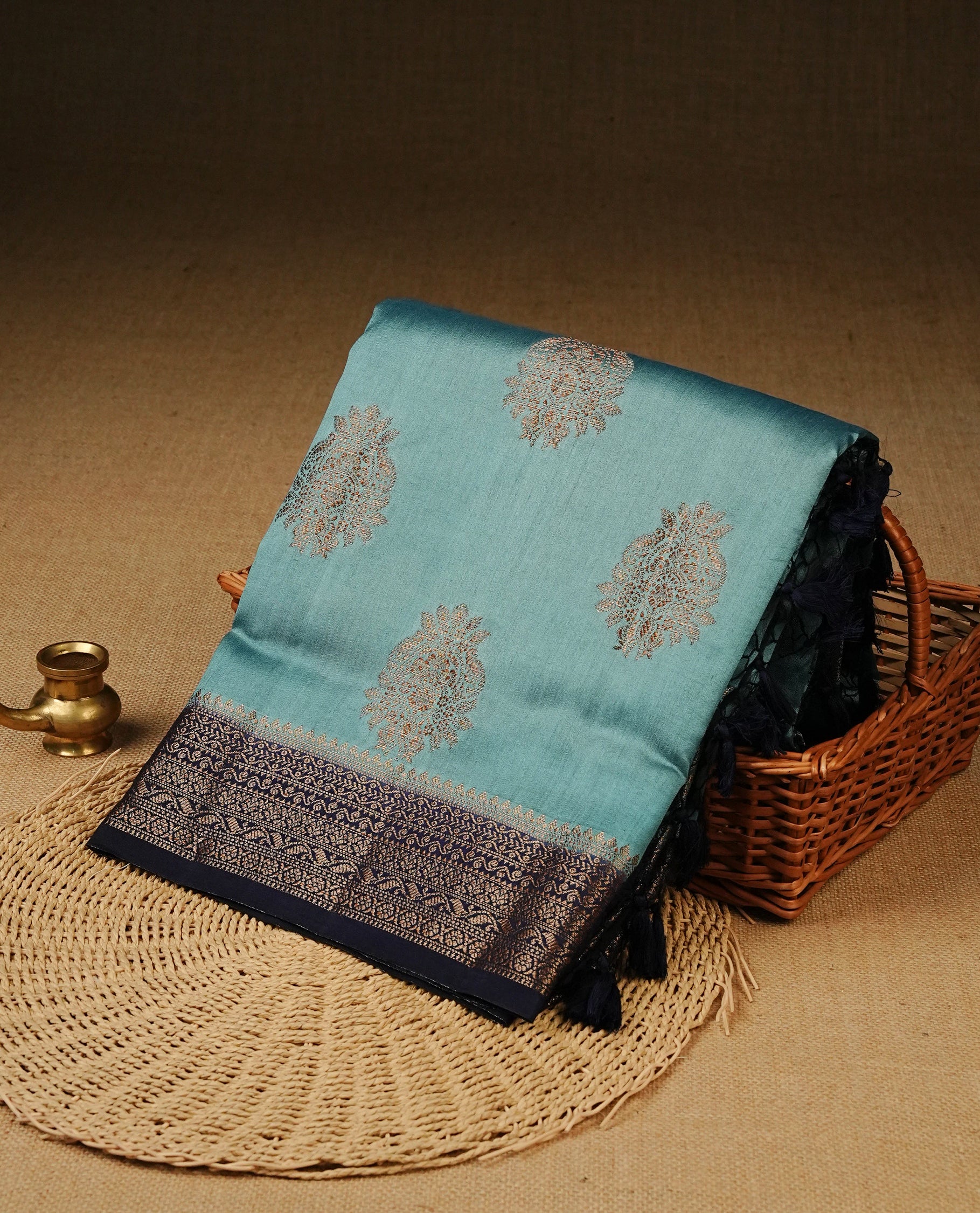 Pastel Aqua Colour Tussar Silk saree with elegant antique zari floral motifs On Body, a contrasting navy blue zari border, a rich zari pallu, Paired With a matching blouse piece.