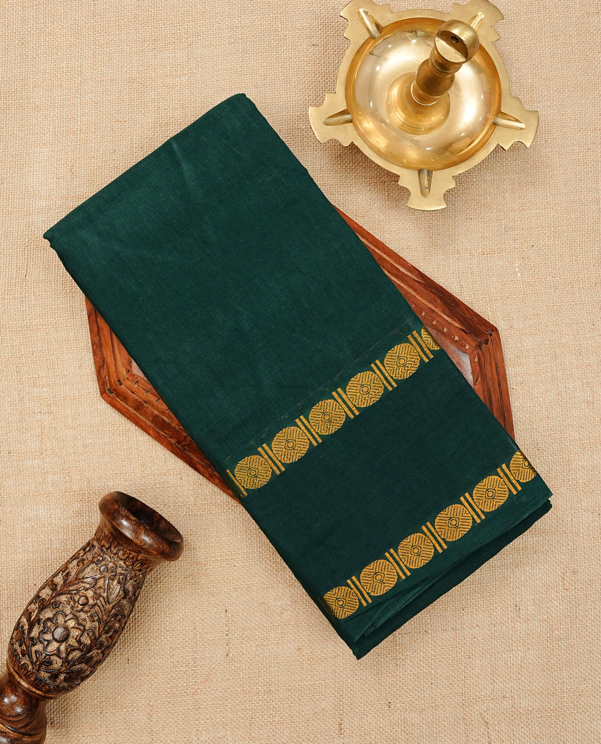 Bottle Green Colour Sungudi Cotton Saree with gold zari motifs on the body, a matching gold zari border, and a plain pallu. Paired with a contrast Red colour blouse piece featuring a gold zari peacock border.