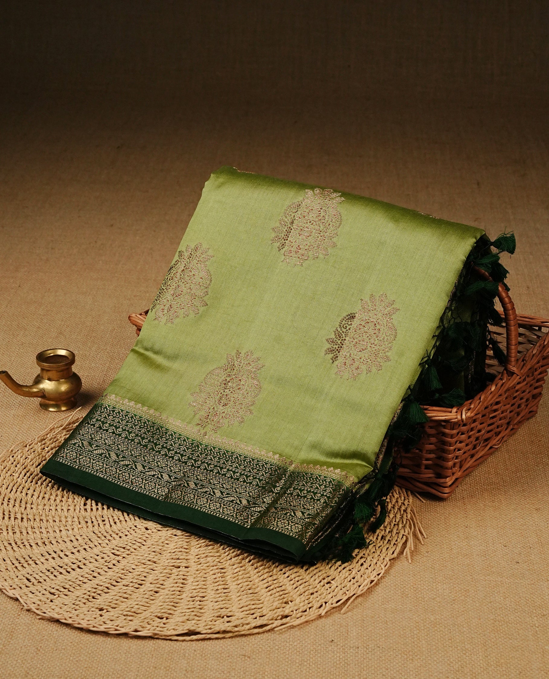 Pastel Pistachio Green Colour Tussar Silk saree with elegant antique zari floral motifs On Body, a contrasting dark green zari border, a rich zari pallu, and a matching blouse piece.