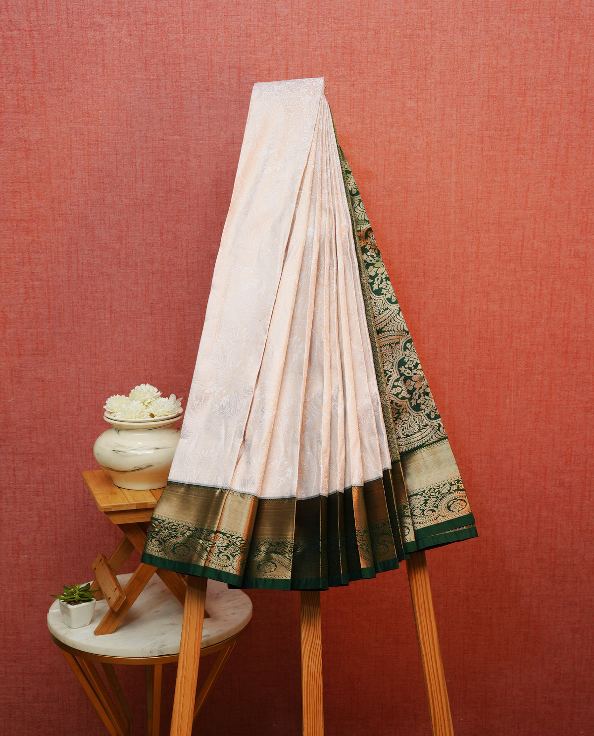 Off white colour silk saree featuring gold zari floral patterns on body, contrast dark green with gold zari traditional border, contrast grand pallu comes with matching blouse piece .